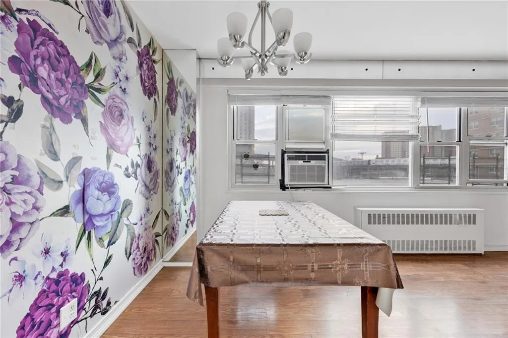 Dining room featuring a chandelier, wood finished floors, and radiator Dining room featuring a chandelier, wood finished floors, and radiator