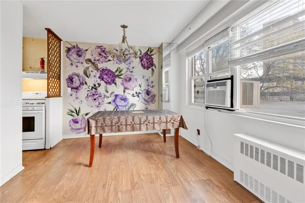 Dining area with radiator, light wood-style floors, and a chandelier Dining area with radiator, light wood-style floors, and a chandelier