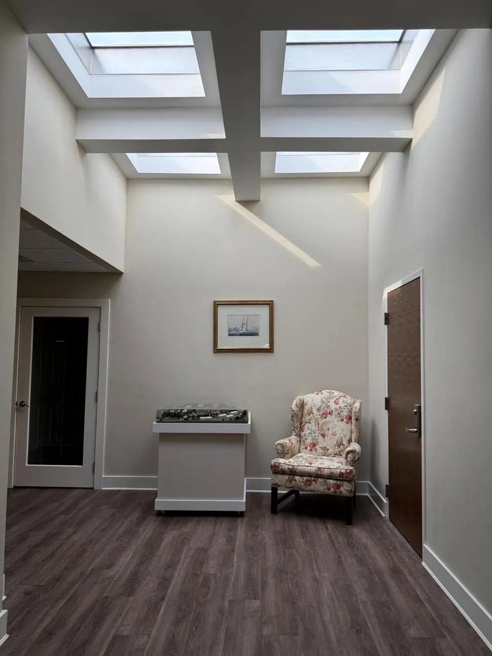 Sitting room featuring a skylight, dark wood-style flooring, and a towering ceiling Sitting room featuring a skylight, dark wood-style flooring, and a towering ceiling