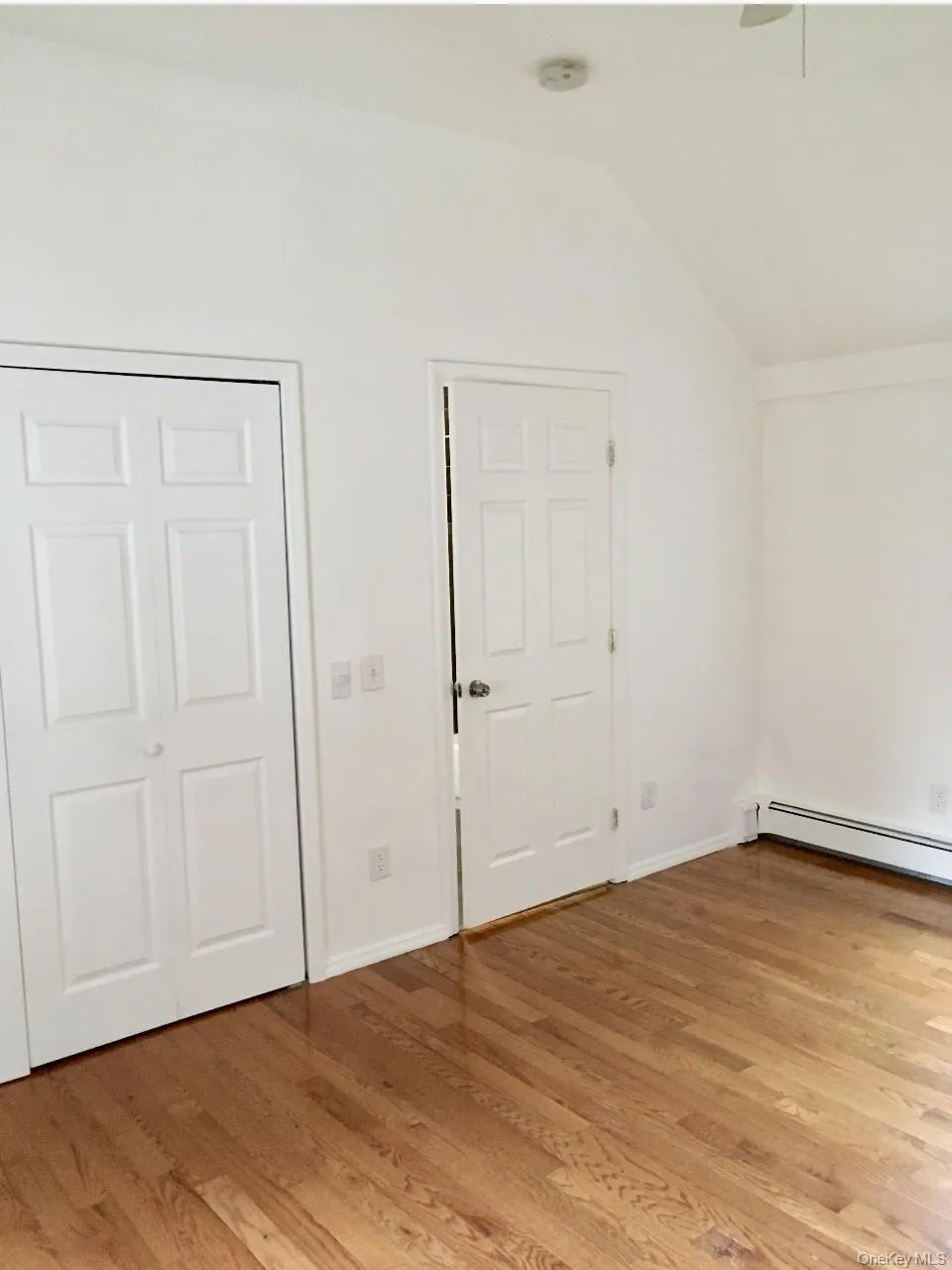 Bonus room with light wood-style floors, lofted ceiling, a baseboard radiator, and ceiling fan Bonus room with light wood-style floors, lofted ceiling, a baseboard radiator, and ceiling fan