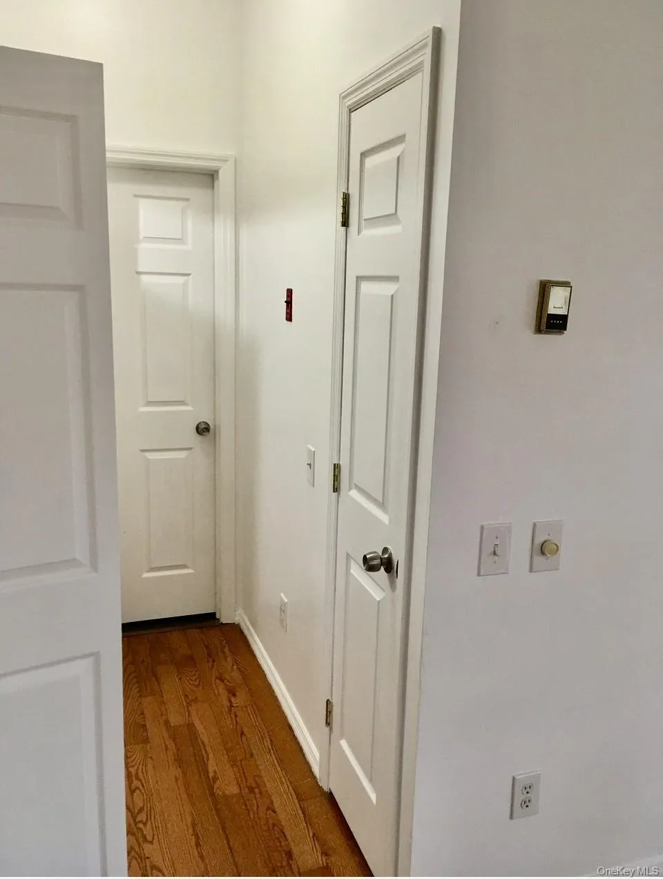Corridor with dark wood-type flooring and baseboards Corridor with dark wood-type flooring and baseboards