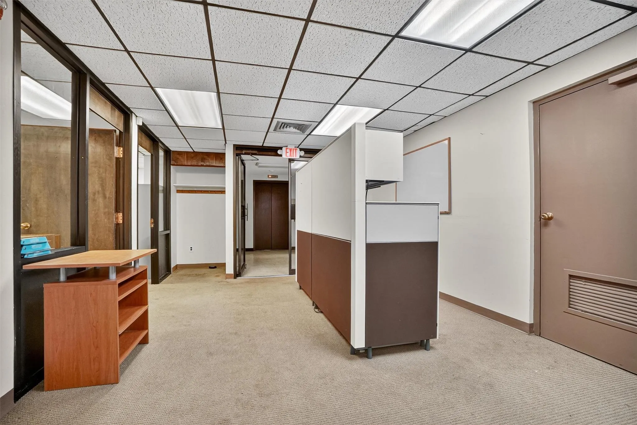 Corridor with light colored carpet and a drop ceiling Corridor with light colored carpet and a drop ceiling