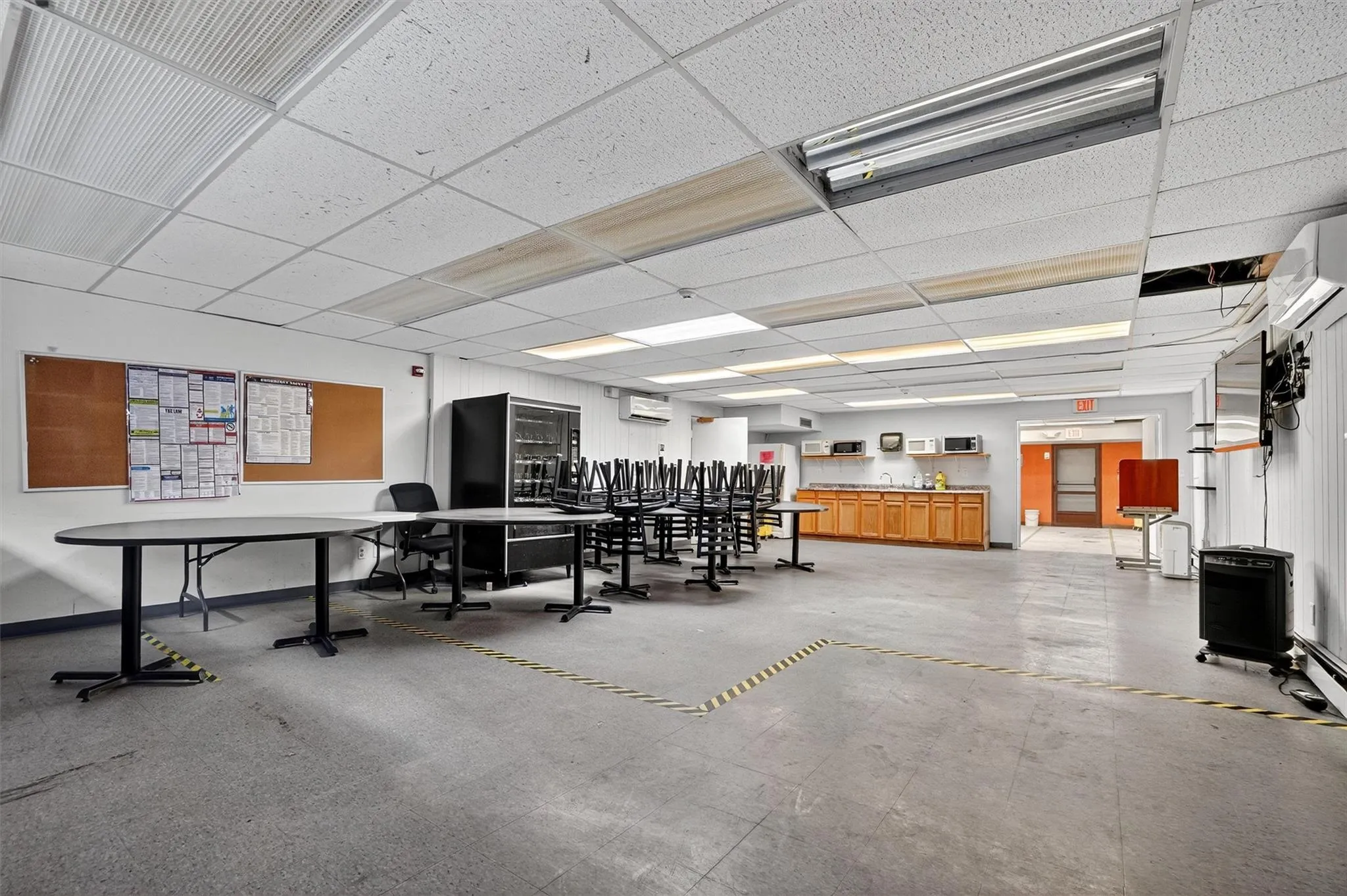 Misc room with a drop ceiling and a wall mounted air conditioner Misc room with a drop ceiling and a wall mounted air conditioner
