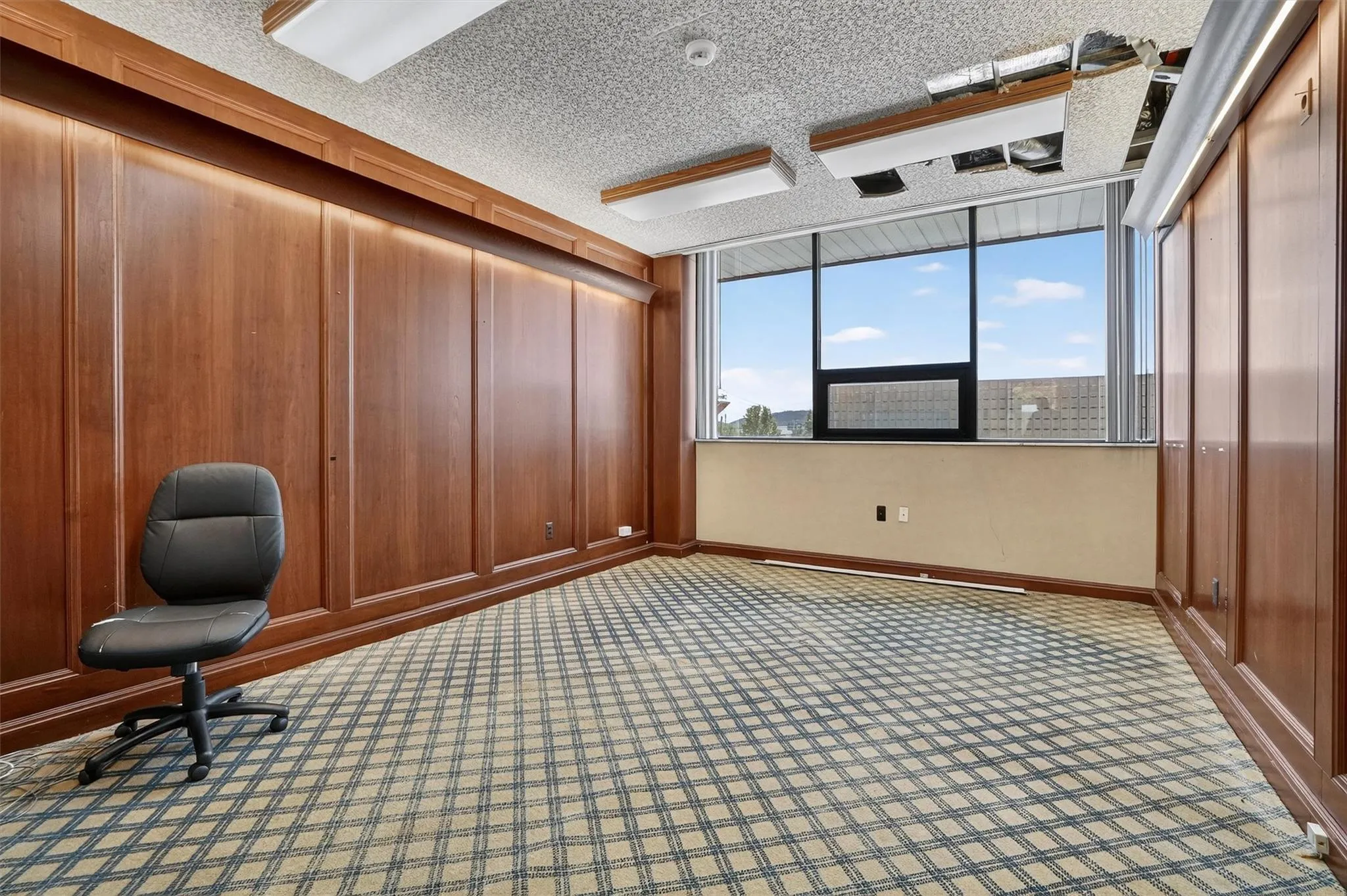 Unfurnished office with carpet and a textured ceiling Unfurnished office with carpet and a textured ceiling