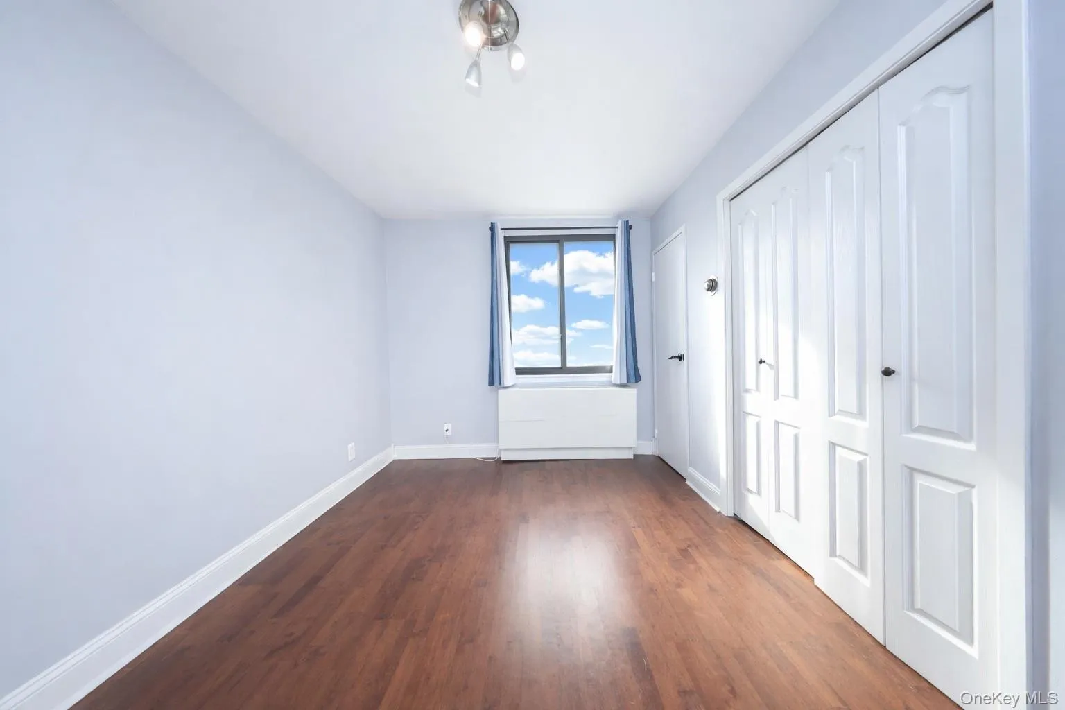 Unfurnished bedroom with a closet and dark wood-style floors Unfurnished bedroom with a closet and dark wood-style floors