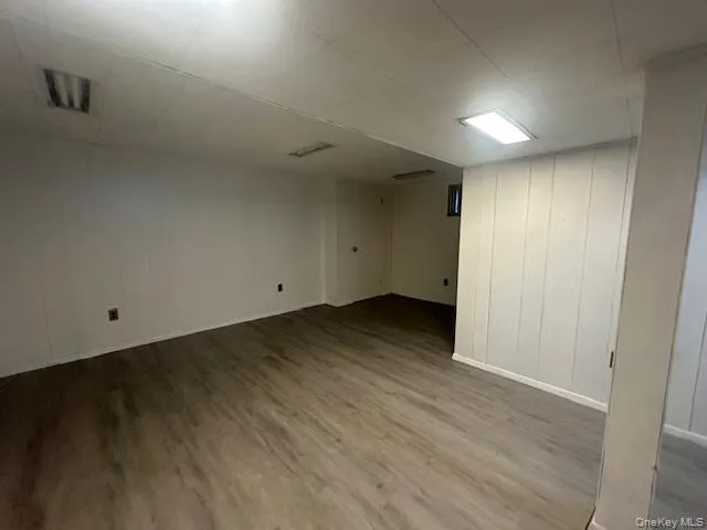 Finished below grade area with wood finished floors and baseboards Finished below grade area with wood finished floors and baseboards