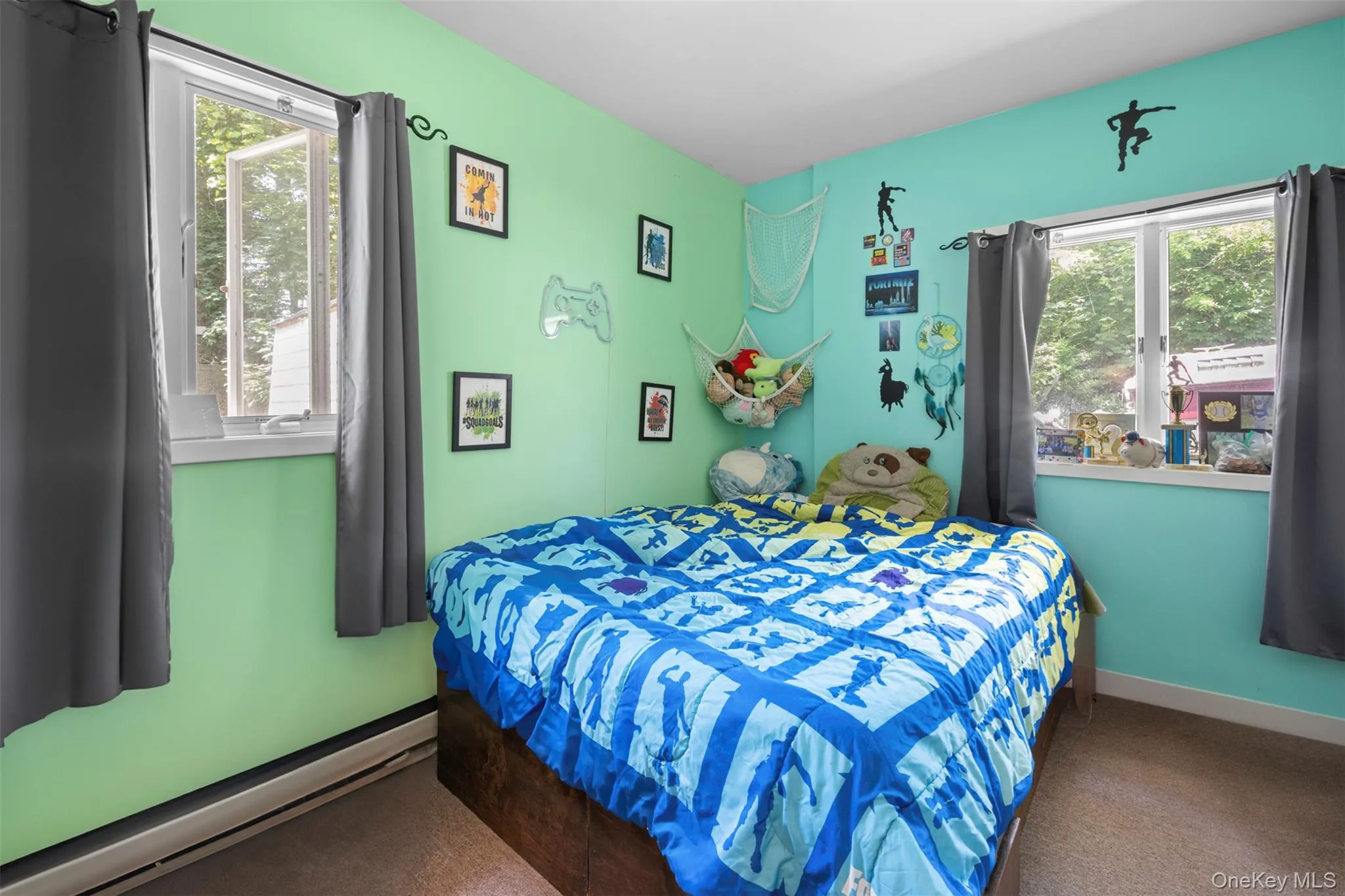 Carpeted bedroom with a baseboard radiator and multiple windows Carpeted bedroom with a baseboard radiator and multiple windows
