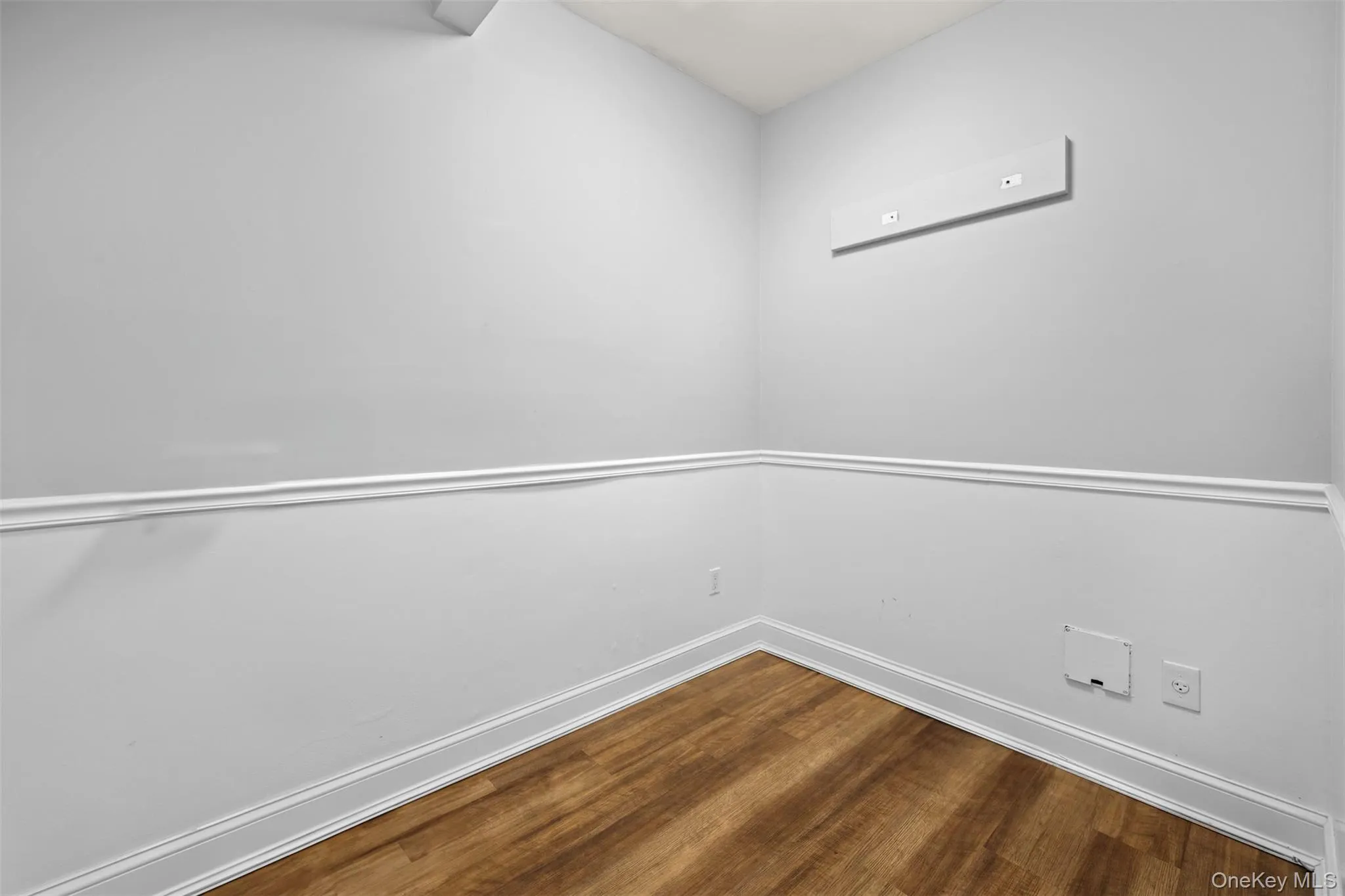 Empty room with wood finished floors and baseboards Empty room with wood finished floors and baseboards