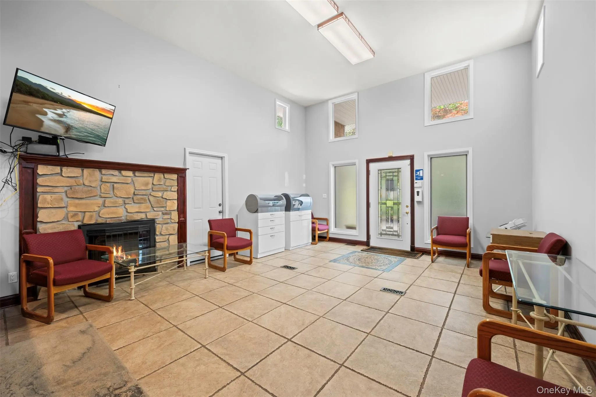 Sitting room with a towering ceiling, light tile patterned floors, and a fireplace Sitting room with a towering ceiling, light tile patterned floors, and a fireplace