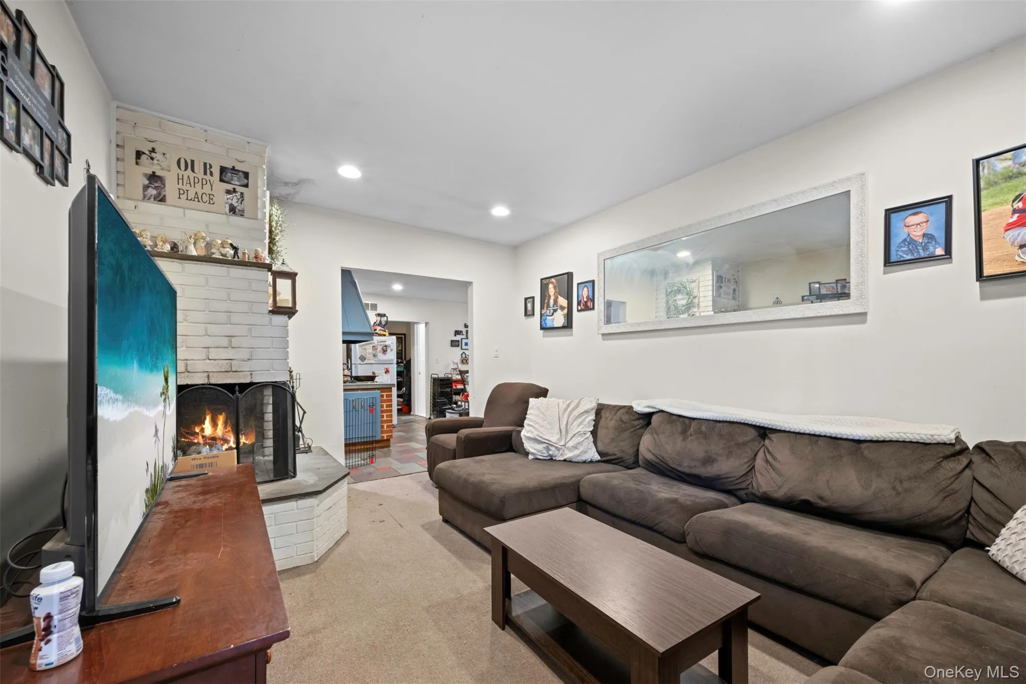 Living room featuring a fireplace, recessed lighting, and light carpet Living room featuring a fireplace, recessed lighting, and light carpet