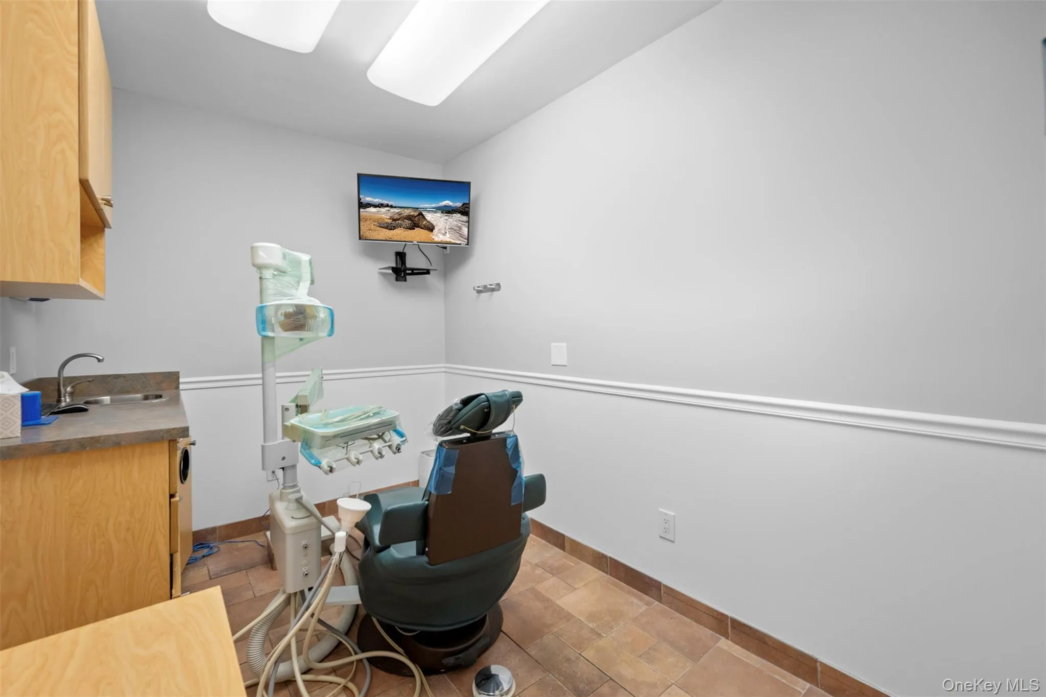 Office area featuring baseboards and light stone finish floors Office area featuring baseboards and light stone finish floors