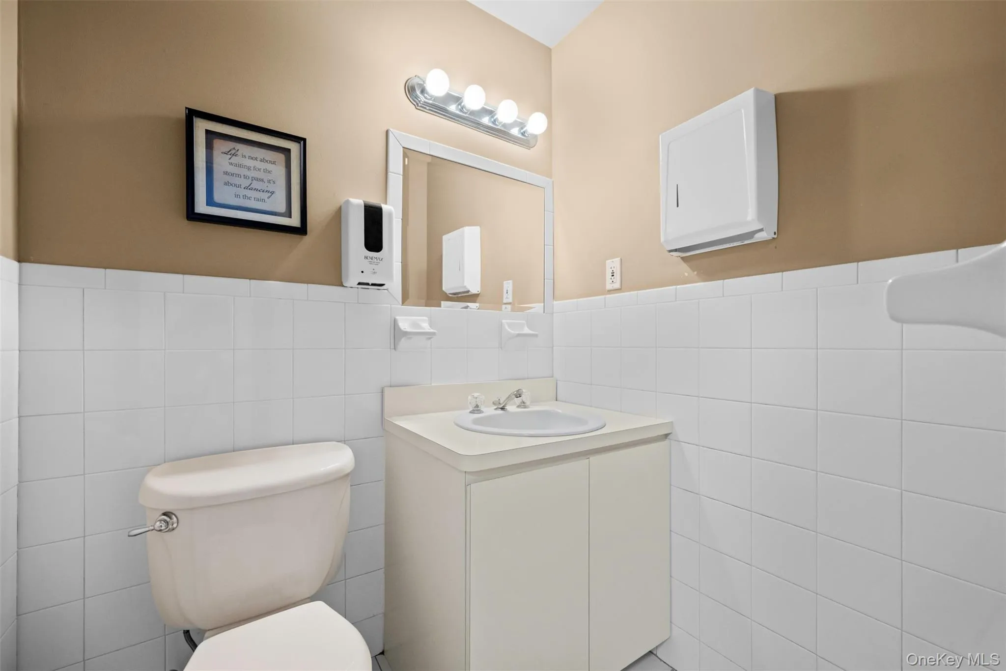 Half bath featuring tile walls, vanity, and wainscoting Half bath featuring tile walls, vanity, and wainscoting