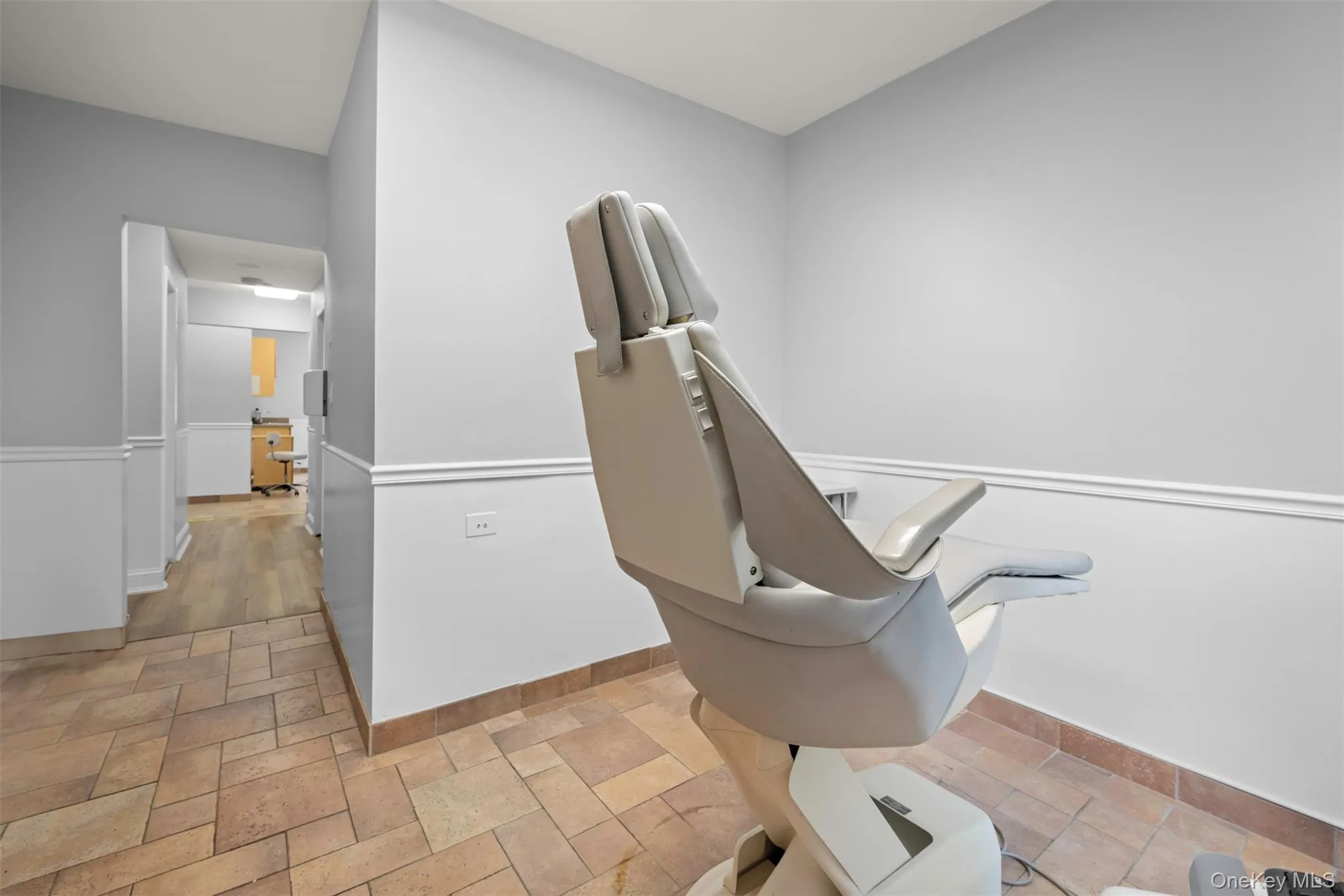 Office space featuring stone tile floors and baseboards Office space featuring stone tile floors and baseboards