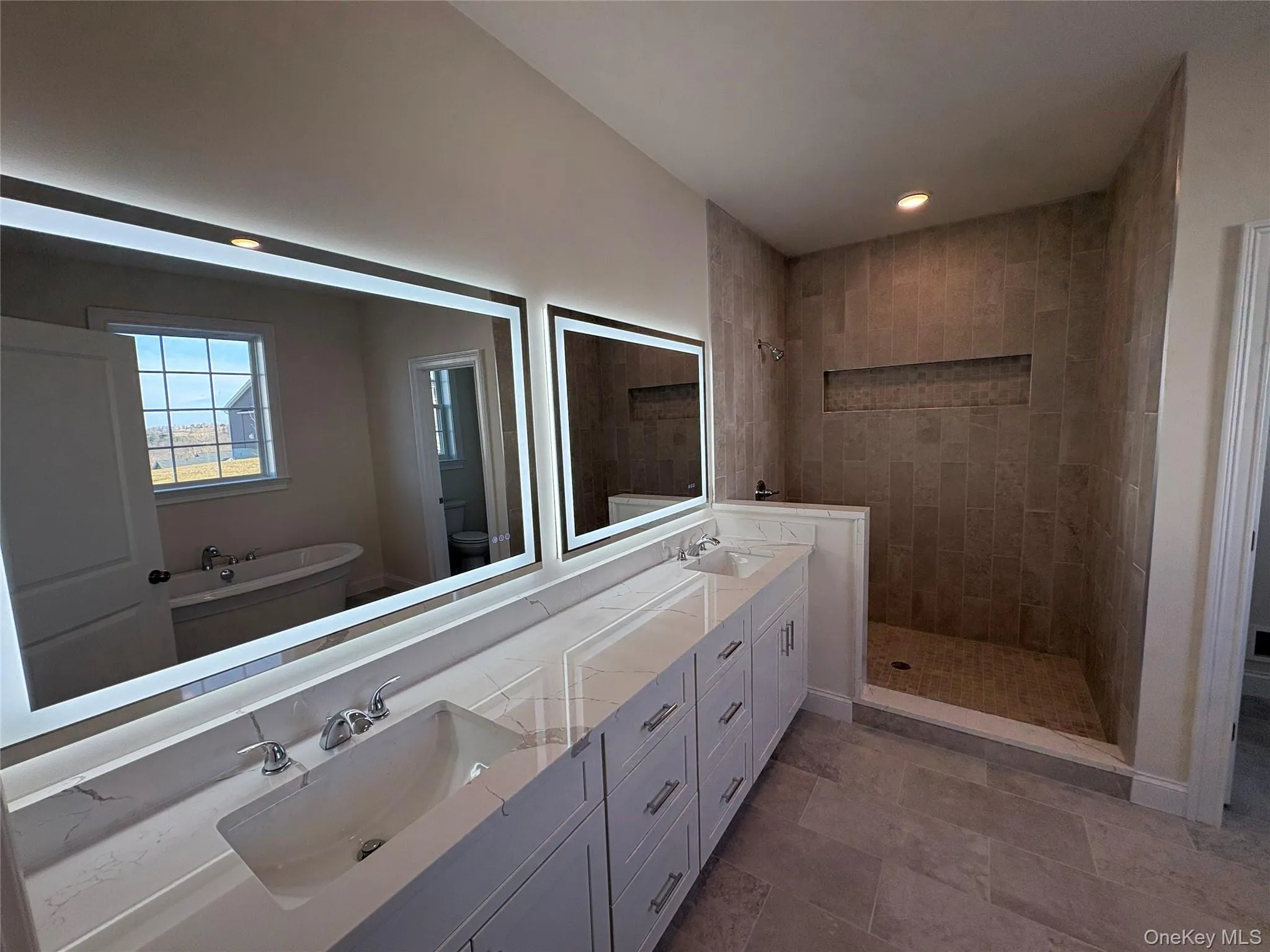 Bathroom with a walk in shower, double vanity, a freestanding bath, and recessed lighting Bathroom with a walk in shower, double vanity, a freestanding bath, and recessed lighting