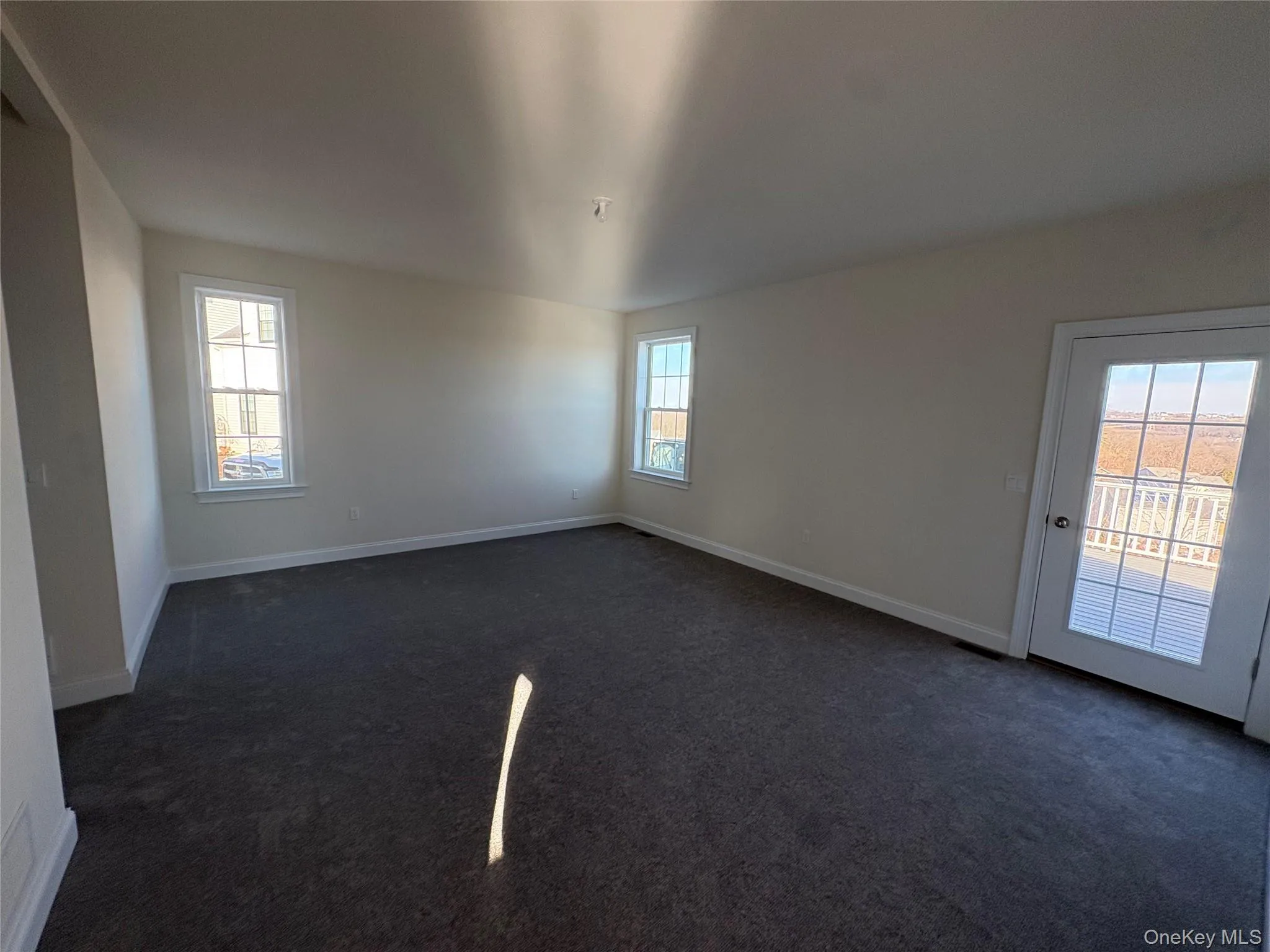 Spare room featuring dark carpet and baseboards Spare room featuring dark carpet and baseboards