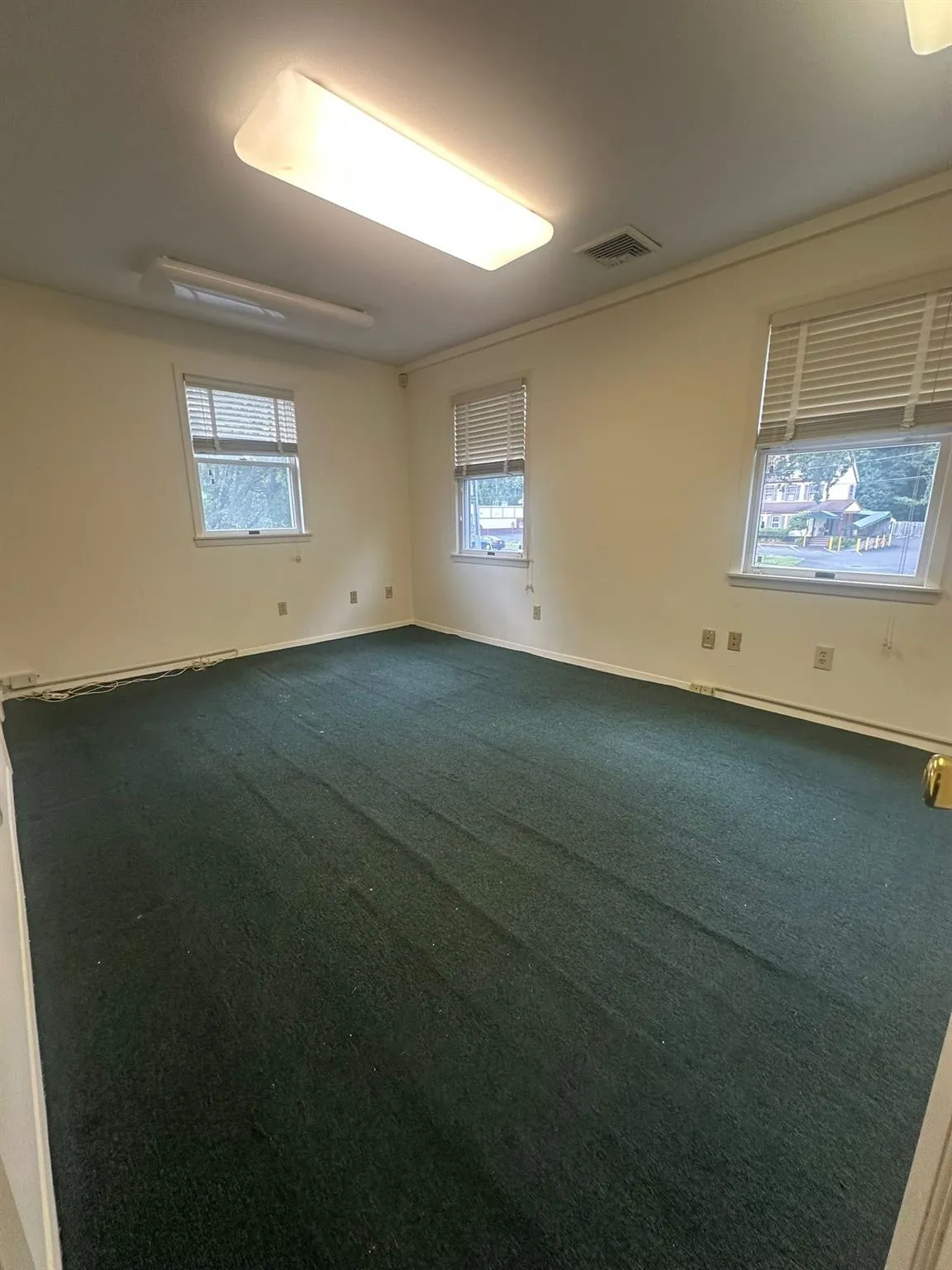 Big Empty room featuring plenty of natural light and dark carpet Big Empty room featuring plenty of natural light and dark carpet