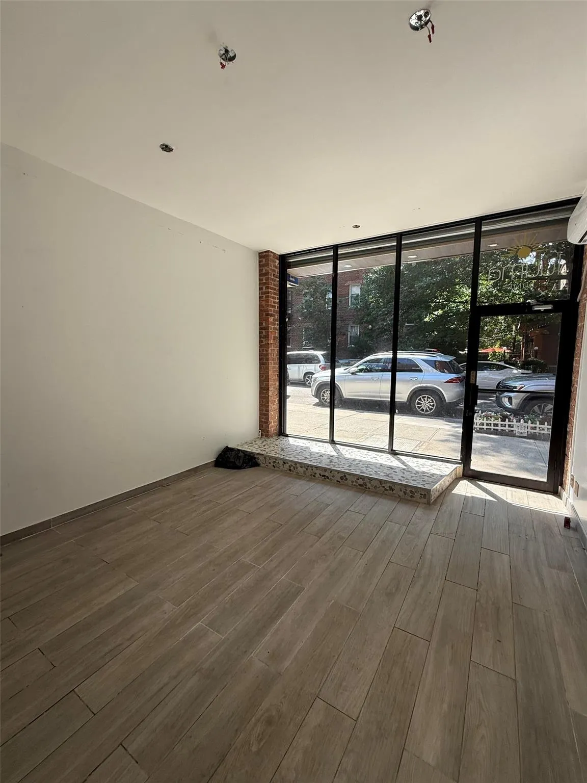 Spare room with floor to ceiling windows and wood finished floors Spare room with floor to ceiling windows and wood finished floors