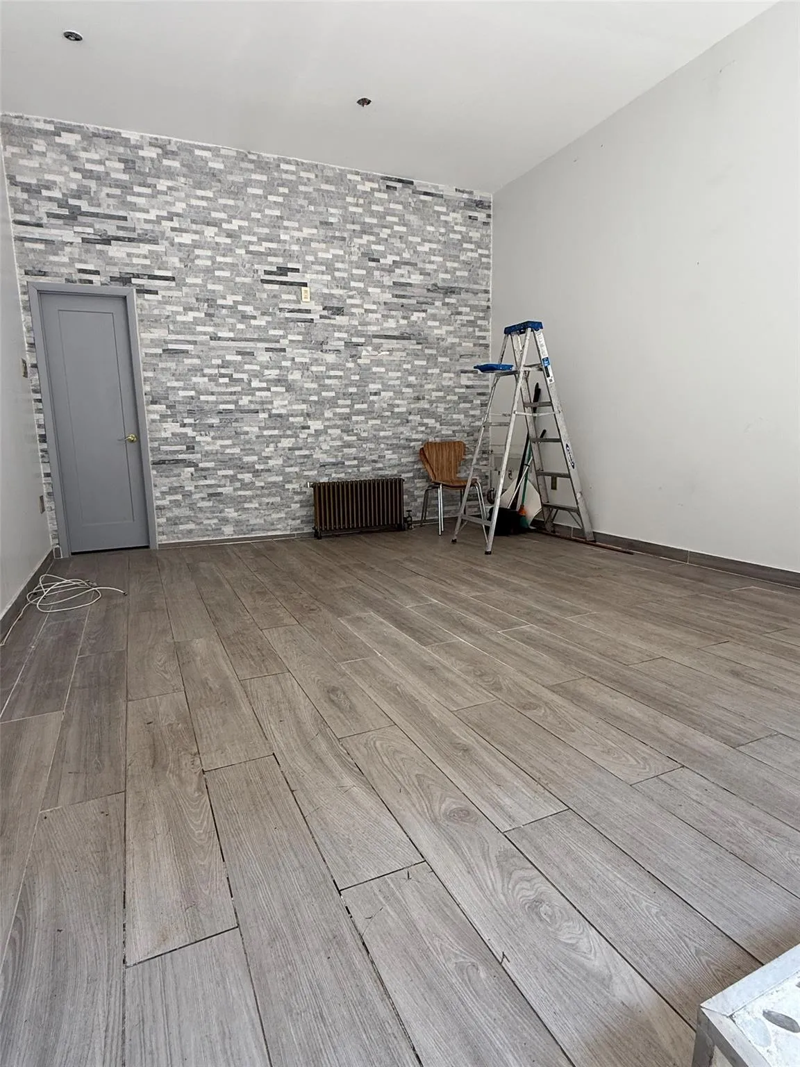 Empty room featuring wood finished floors and radiator Empty room featuring wood finished floors and radiator