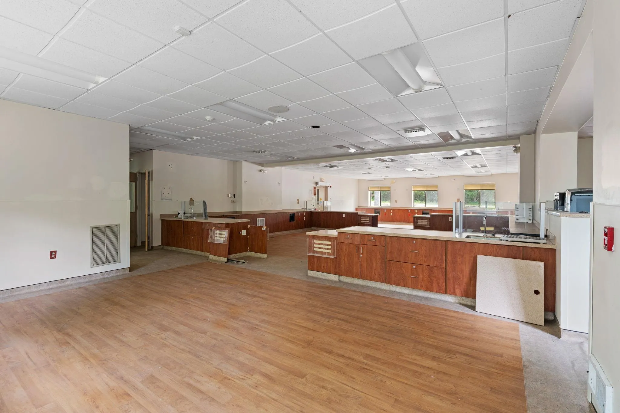 Kitchen featuring brown cabinetry, light wood finished floors, open floor plan, a paneled ceiling, and a peninsula Kitchen featuring brown cabinetry, light wood finished floors, open floor plan, a paneled ceiling, and a peninsula