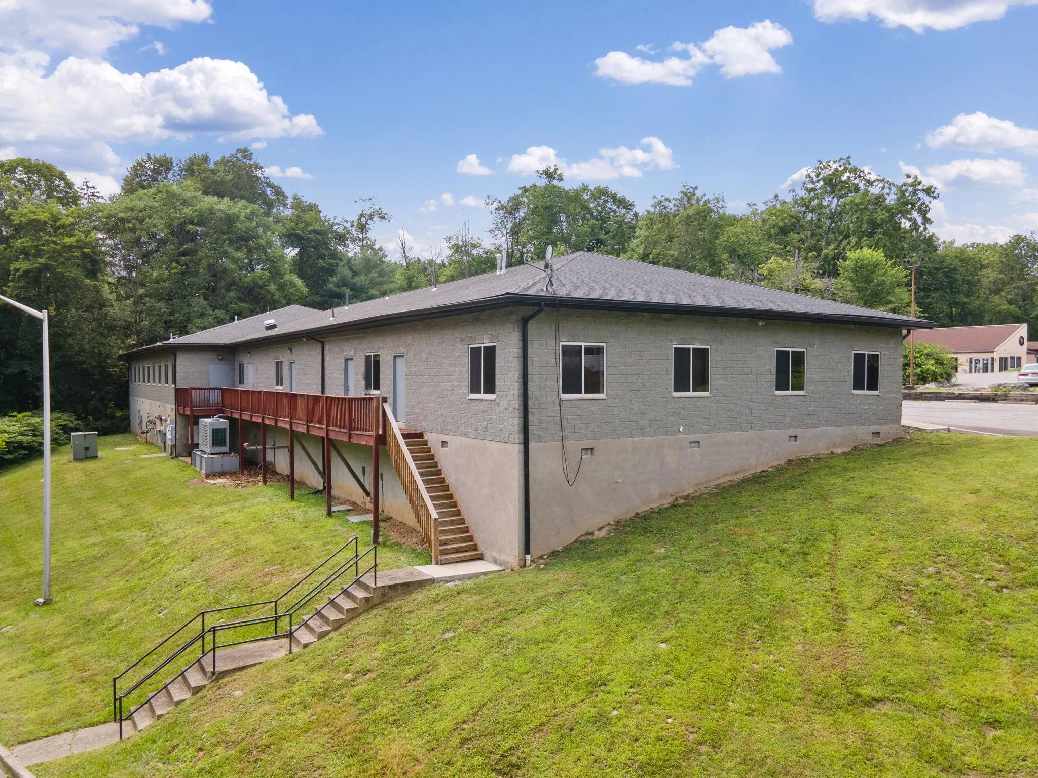 Back of house featuring stairway, crawl space, a lawn, view of scattered trees, and a deck Back of house featuring stairway, crawl space, a lawn, view of scattered trees, and a deck