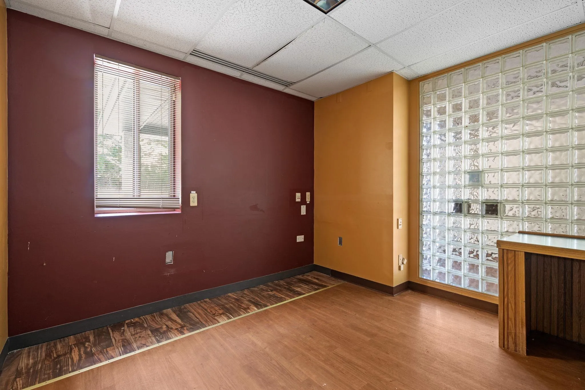 Spare room featuring a drop ceiling and wood finished floors Spare room featuring a drop ceiling and wood finished floors