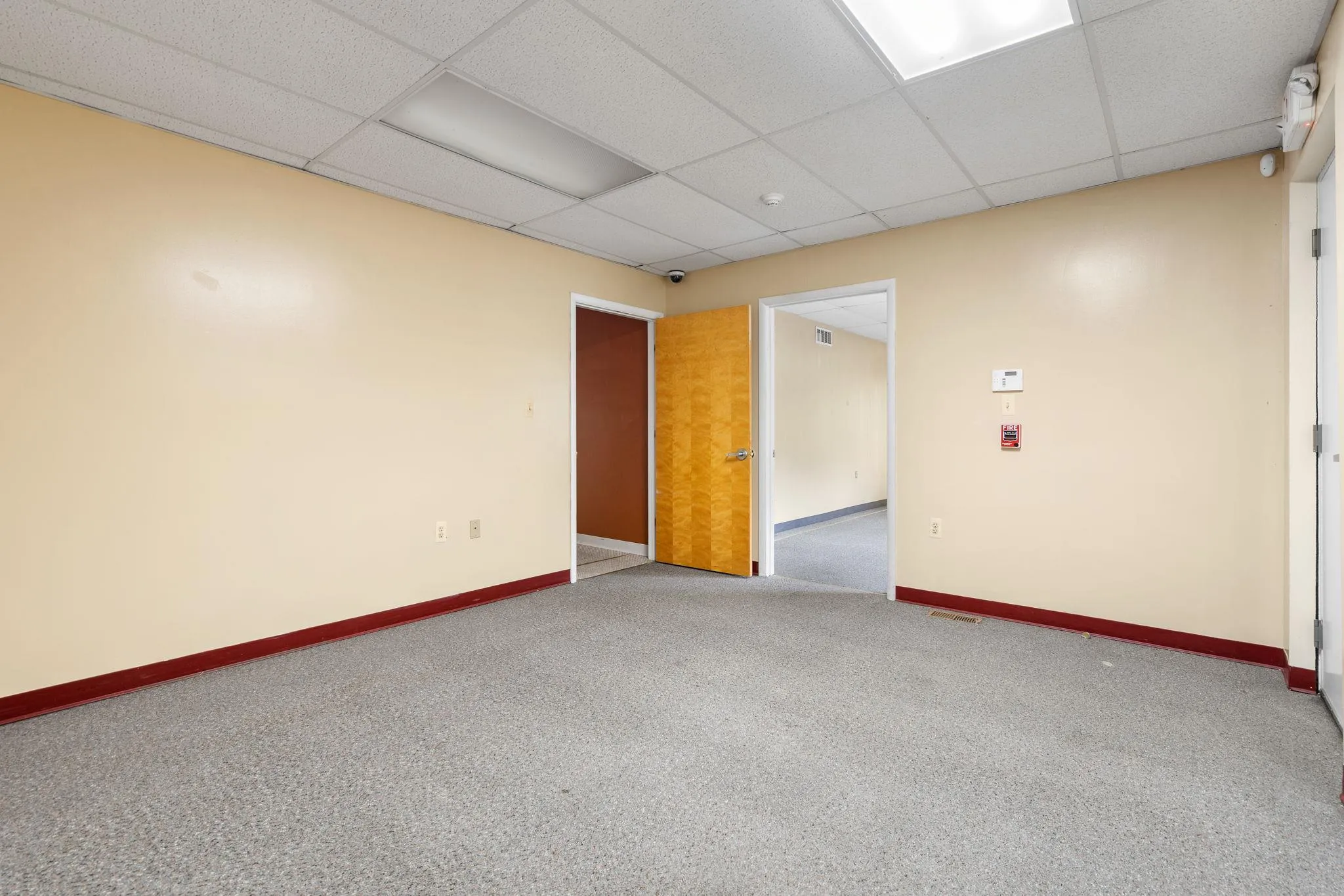 Carpeted spare room with baseboards and a paneled ceiling Carpeted spare room with baseboards and a paneled ceiling