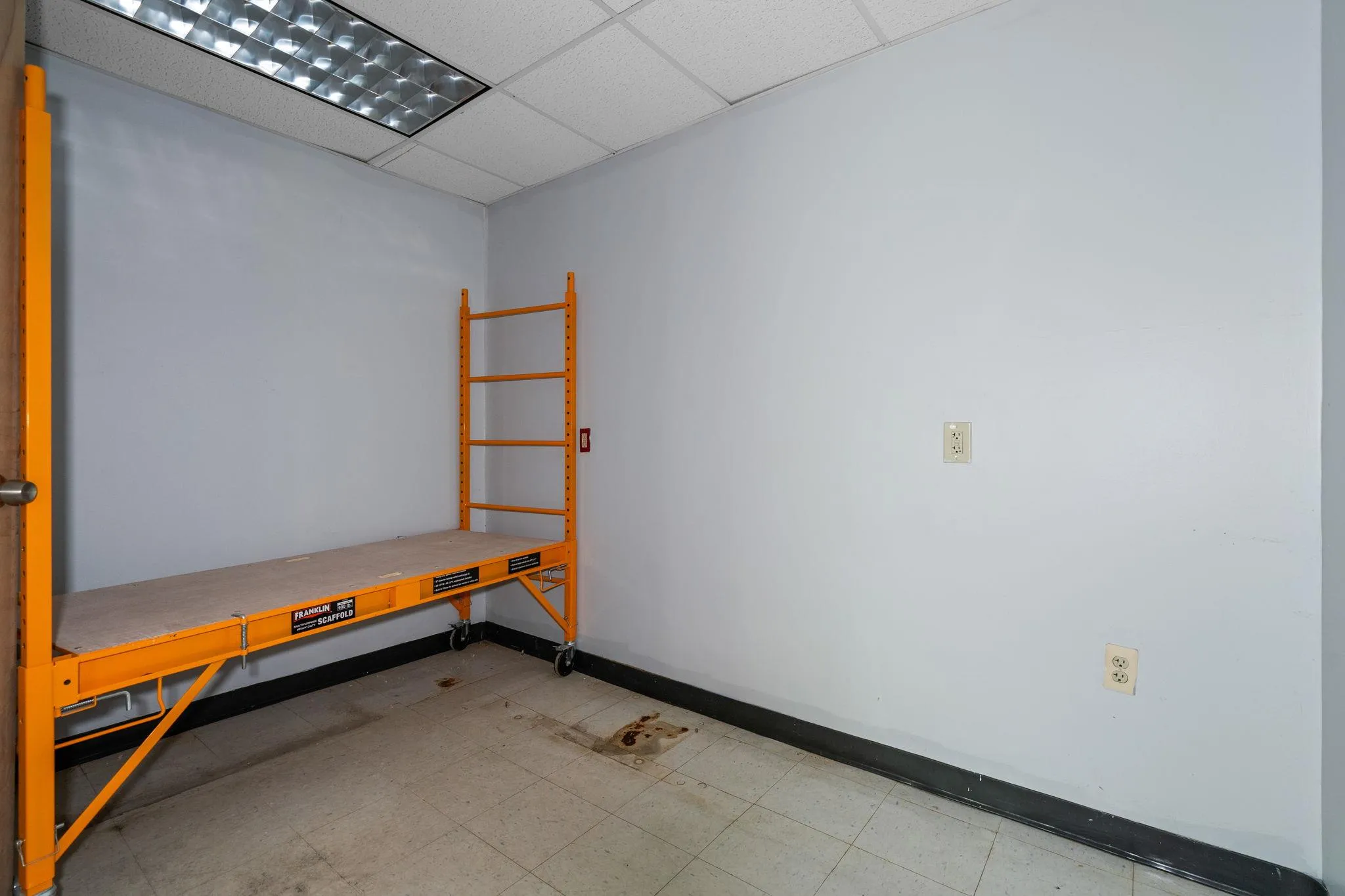 Unfurnished room with tile patterned floors and a drop ceiling Unfurnished room with tile patterned floors and a drop ceiling