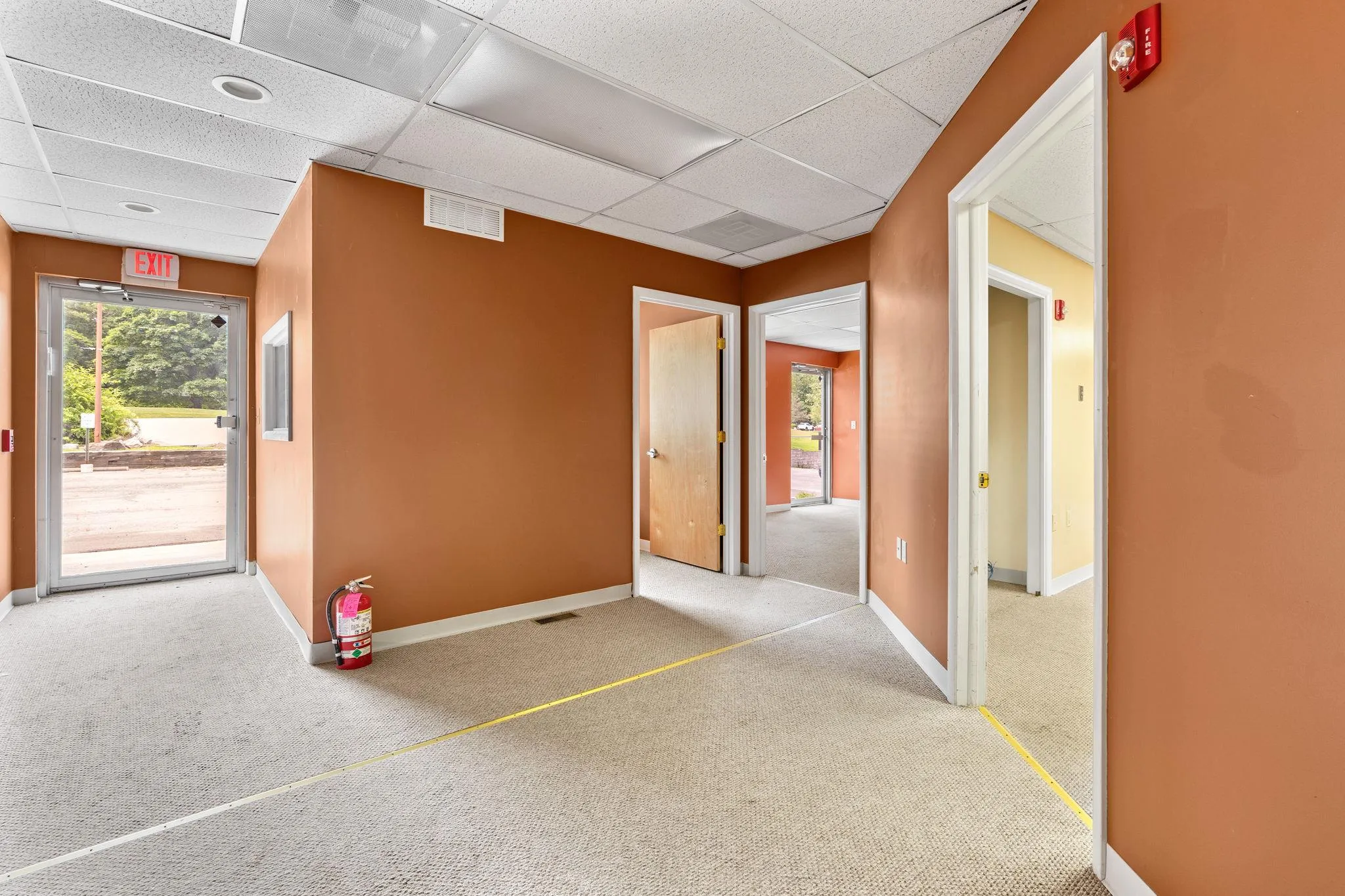 Hall featuring a paneled ceiling and carpet Hall featuring a paneled ceiling and carpet