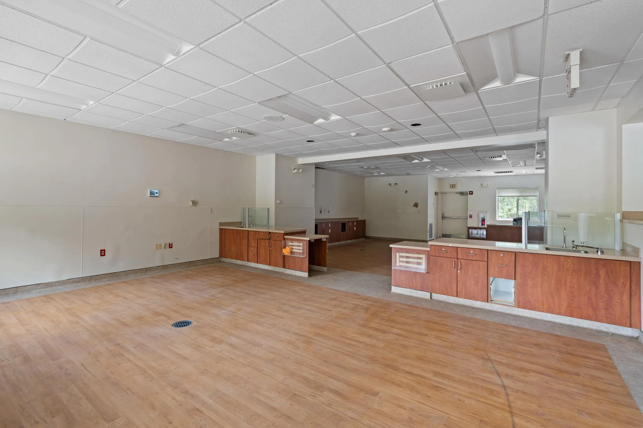 Kitchen featuring brown cabinetry, light wood finished floors, a peninsula, open floor plan, and a paneled ceiling Kitchen featuring brown cabinetry, light wood finished floors, a peninsula, open floor plan, and a paneled ceiling