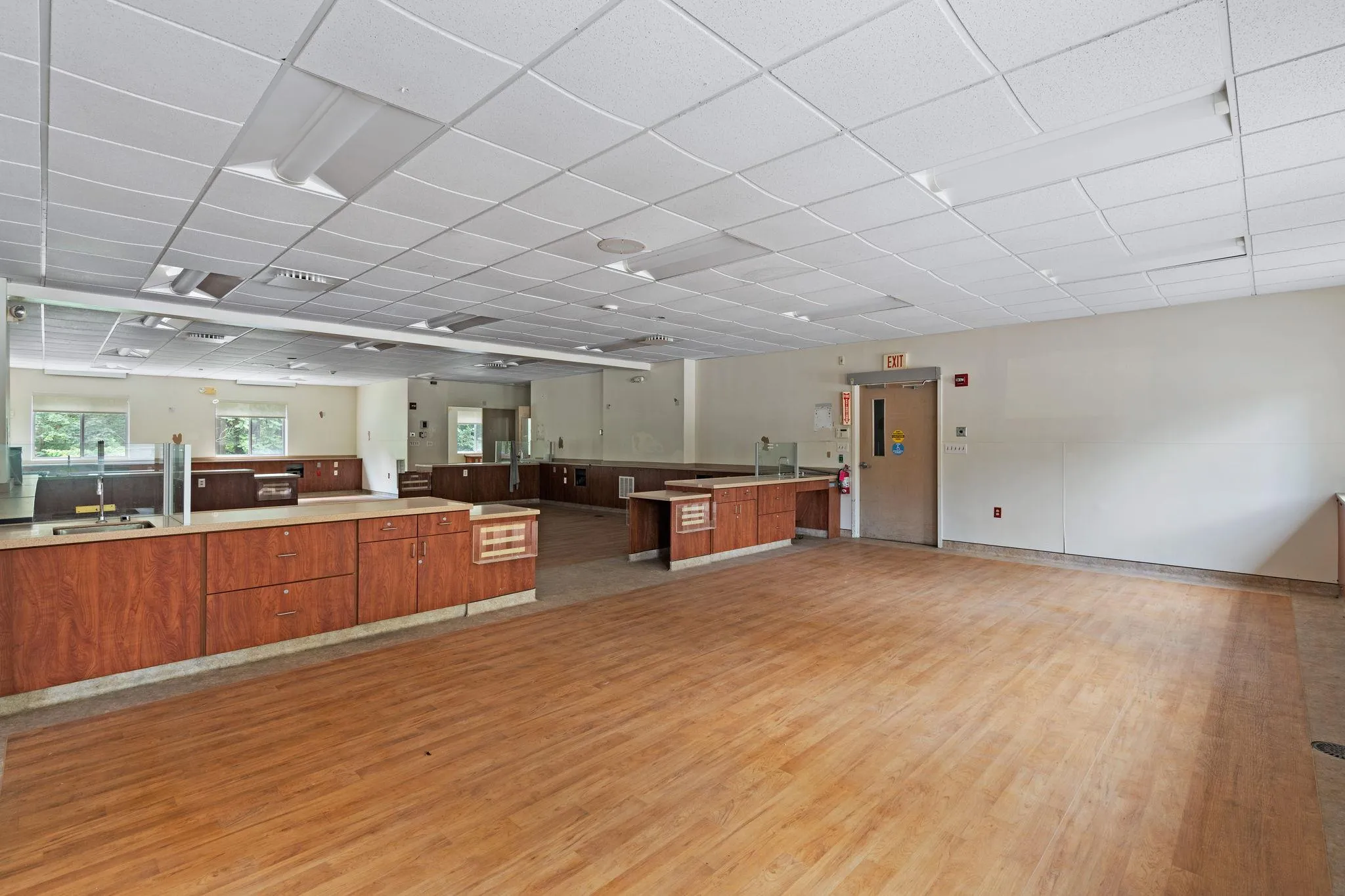 Kitchen with light wood finished floors, open floor plan, brown cabinets, and a drop ceiling Kitchen with light wood finished floors, open floor plan, brown cabinets, and a drop ceiling