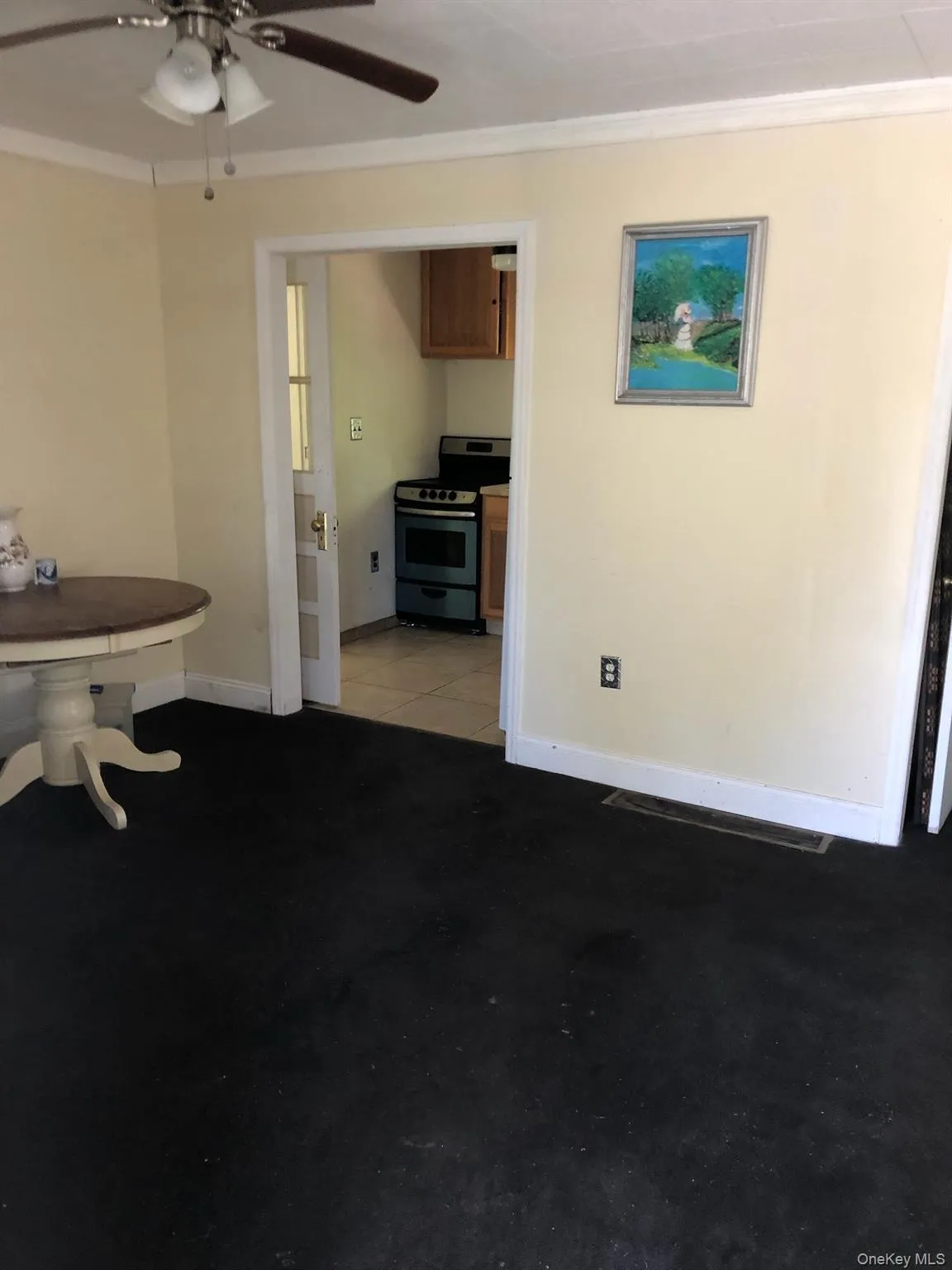 Living area featuring crown molding, a ceiling fan, and concrete floors Living area featuring crown molding, a ceiling fan, and concrete floors