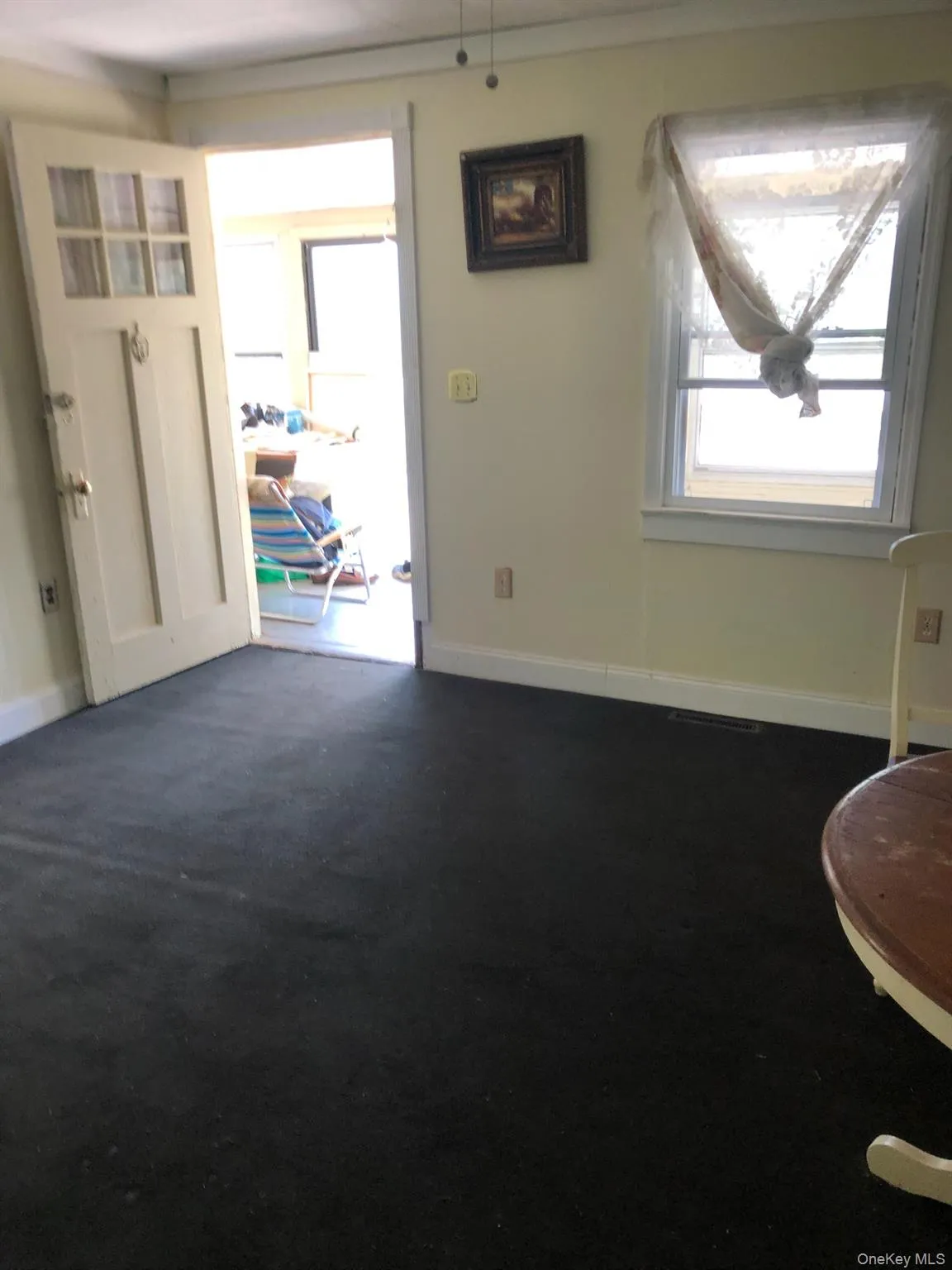 Foyer entrance with baseboards and dark colored carpet Foyer entrance with baseboards and dark colored carpet
