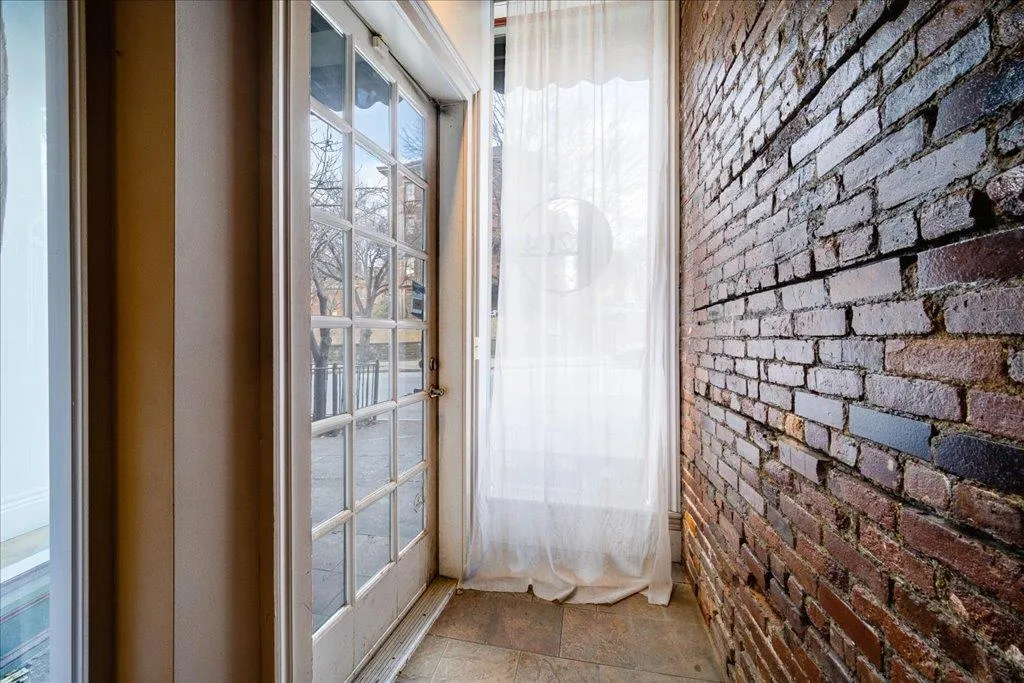 Doorway to outside with brick wall Doorway to outside with brick wall