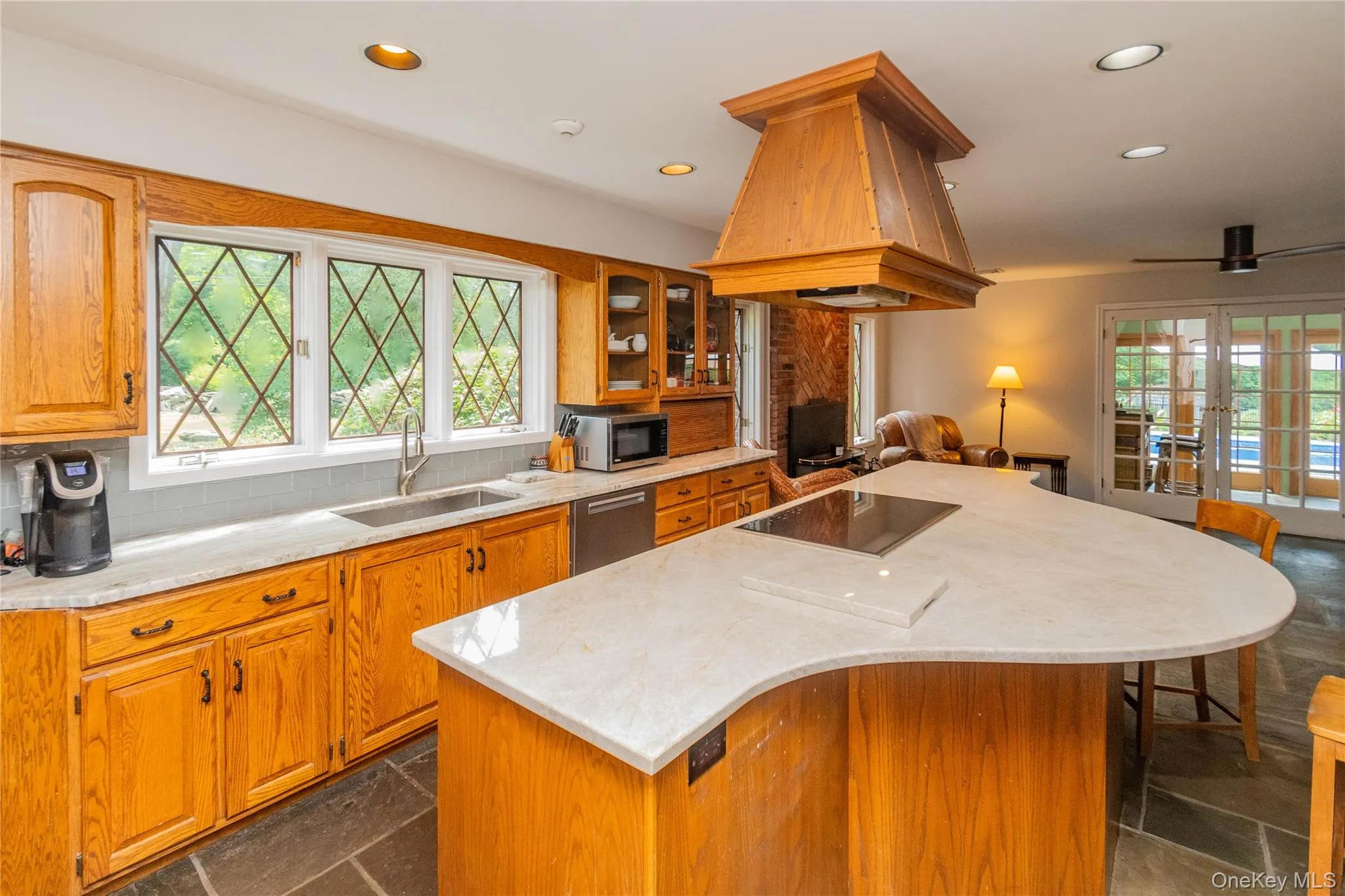 Kitchen featuring plenty of natural light, french doors, recessed lighting, island range hood Kitchen featuring plenty of natural light, french doors, recessed lighting, island range hood