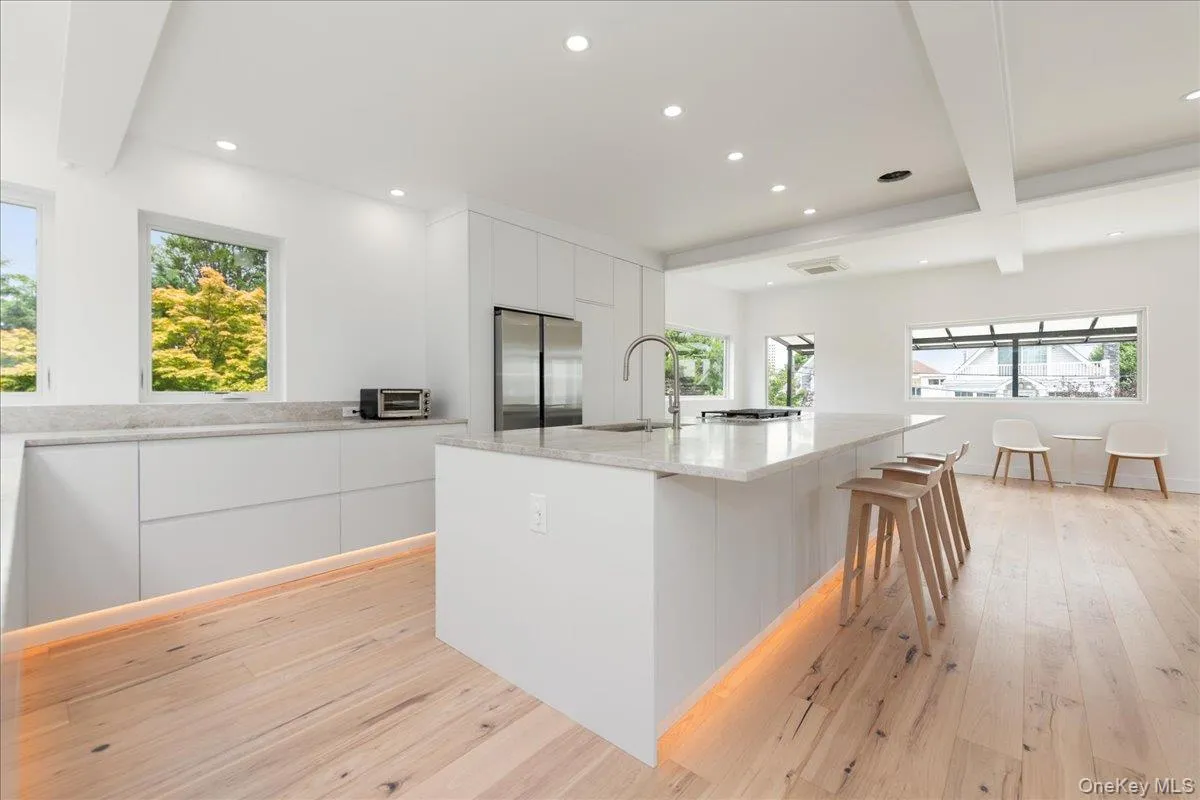 Kitchen featuring modern cabinets, recessed lighting, light wood-style floors, white cabinetry, and beam ceiling Kitchen featuring modern cabinets, recessed lighting, light wood-style floors, white cabinetry, and beam ceiling