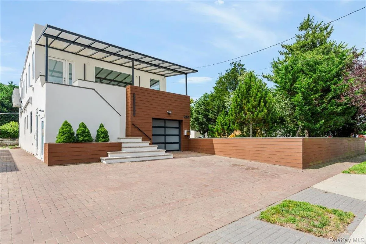 View of front of home featuring stucco siding, decorative driveway, and a garage View of front of home featuring stucco siding, decorative driveway, and a garage