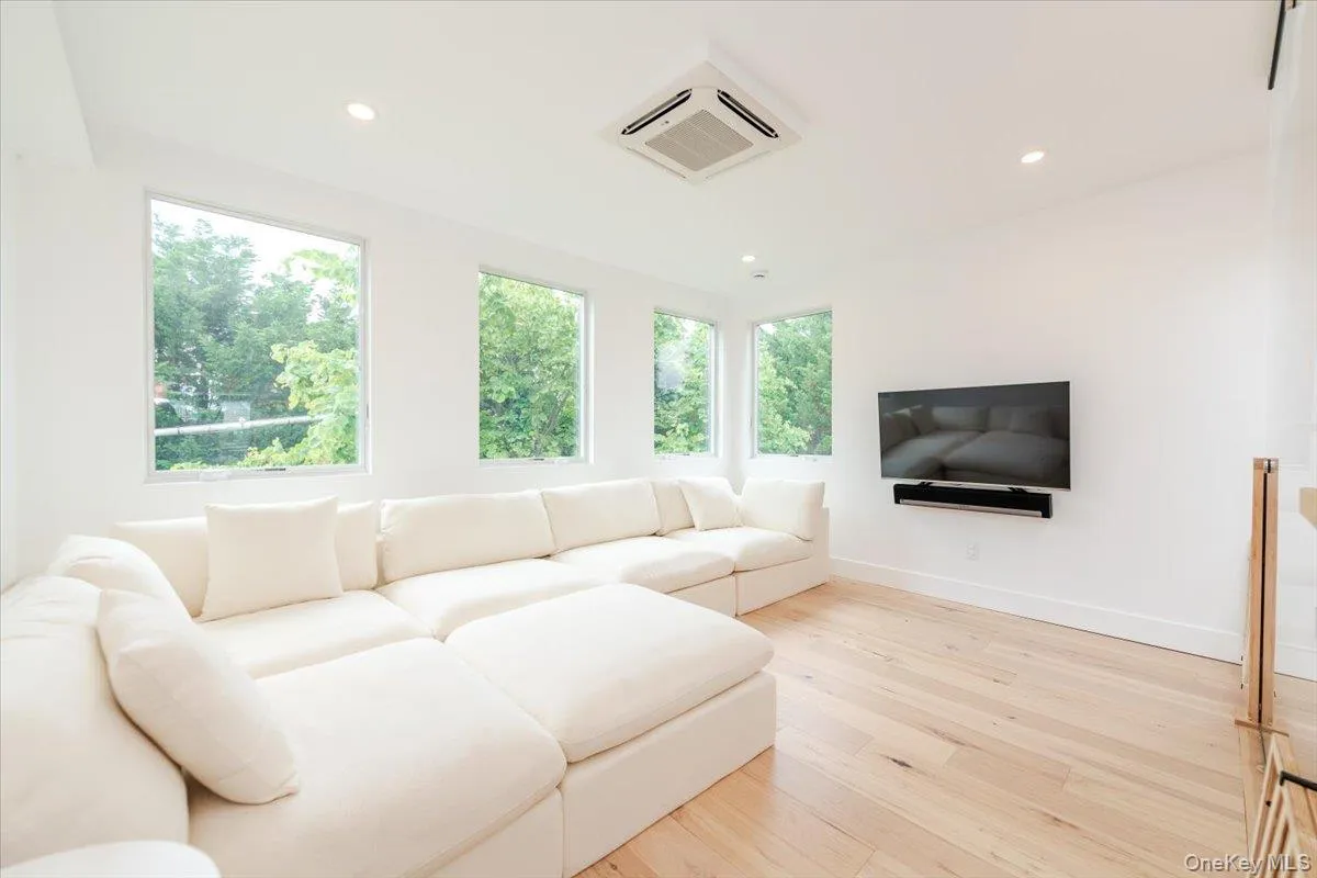 Living room featuring cooling unit, light wood-type flooring, and recessed lighting Living room featuring cooling unit, light wood-type flooring, and recessed lighting