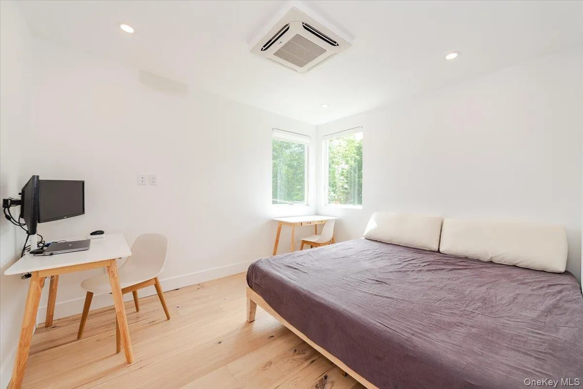 Bedroom with light wood-style floors, cooling unit, and recessed lighting Bedroom with light wood-style floors, cooling unit, and recessed lighting