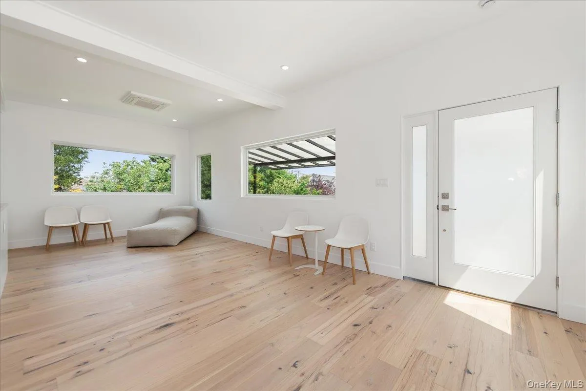 Sitting room with plenty of natural light, light wood finished floors, beamed ceiling, and recessed lighting Sitting room with plenty of natural light, light wood finished floors, beamed ceiling, and recessed lighting