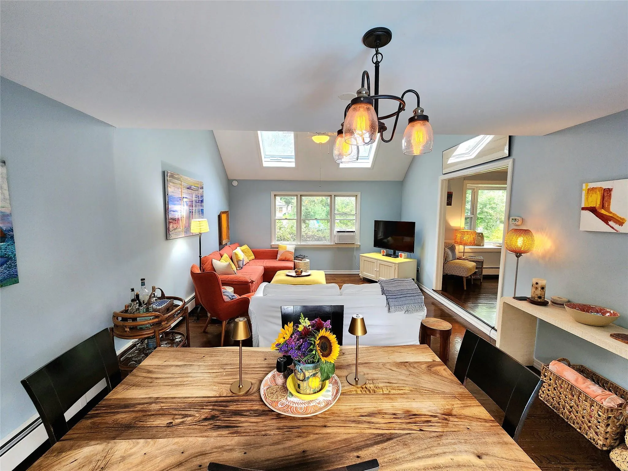 Dining space featuring a skylight, lofted ceiling, and a baseboard radiator Dining space featuring a skylight, lofted ceiling, and a baseboard radiator