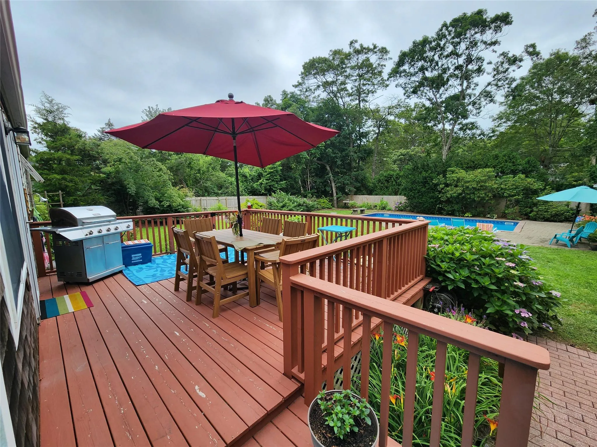 Wooden terrace with outdoor dining area, grilling area, and view of scattered trees Wooden terrace with outdoor dining area, grilling area, and view of scattered trees