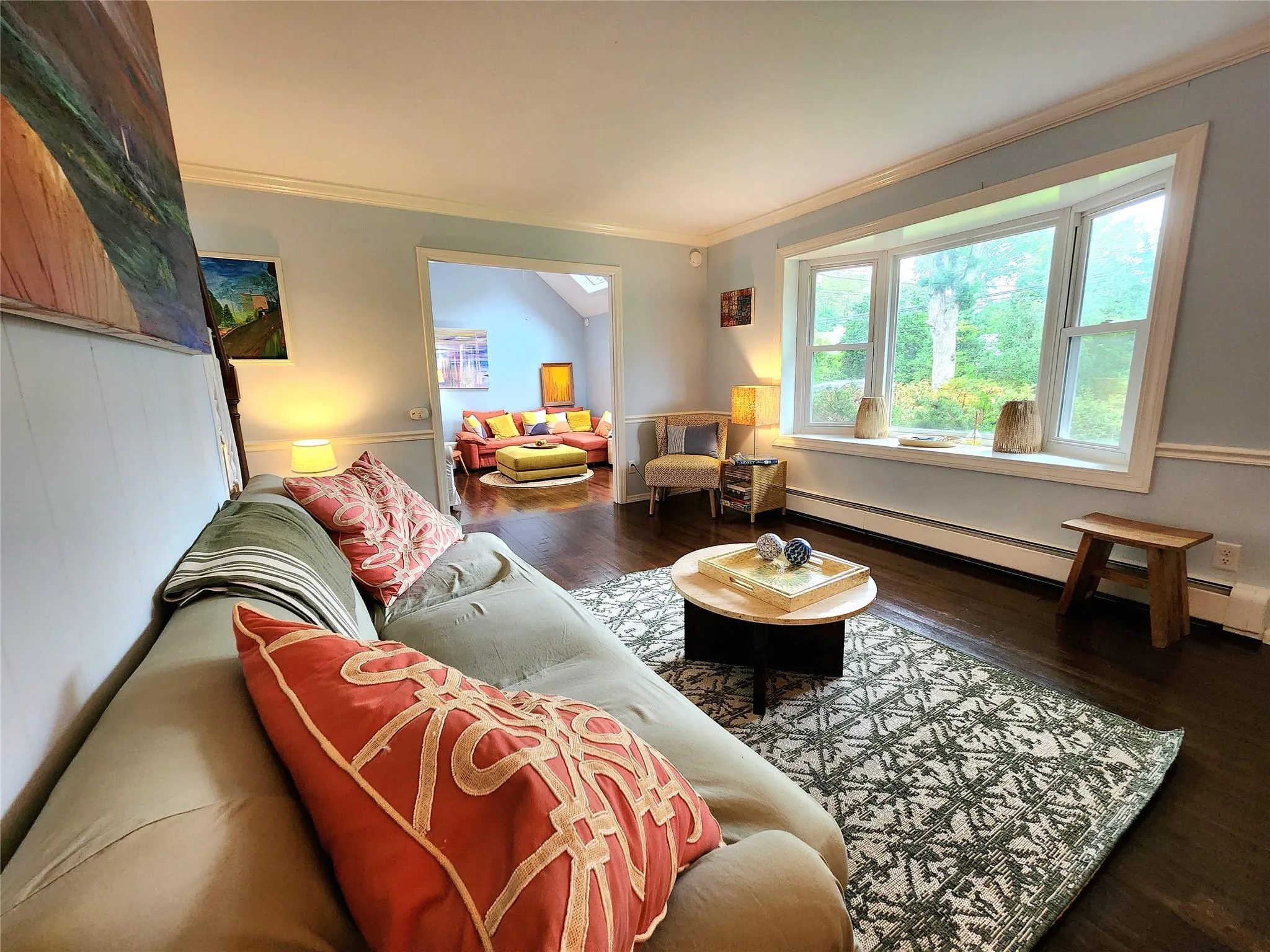 Living room with a baseboard heating unit, ornamental molding, and wood finished floors Living room with a baseboard heating unit, ornamental molding, and wood finished floors