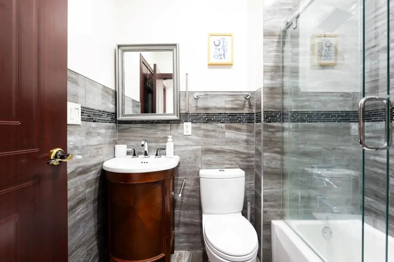 Full bathroom with vanity, enclosed tub / shower combo, and tile walls Full bathroom with vanity, enclosed tub / shower combo, and tile walls