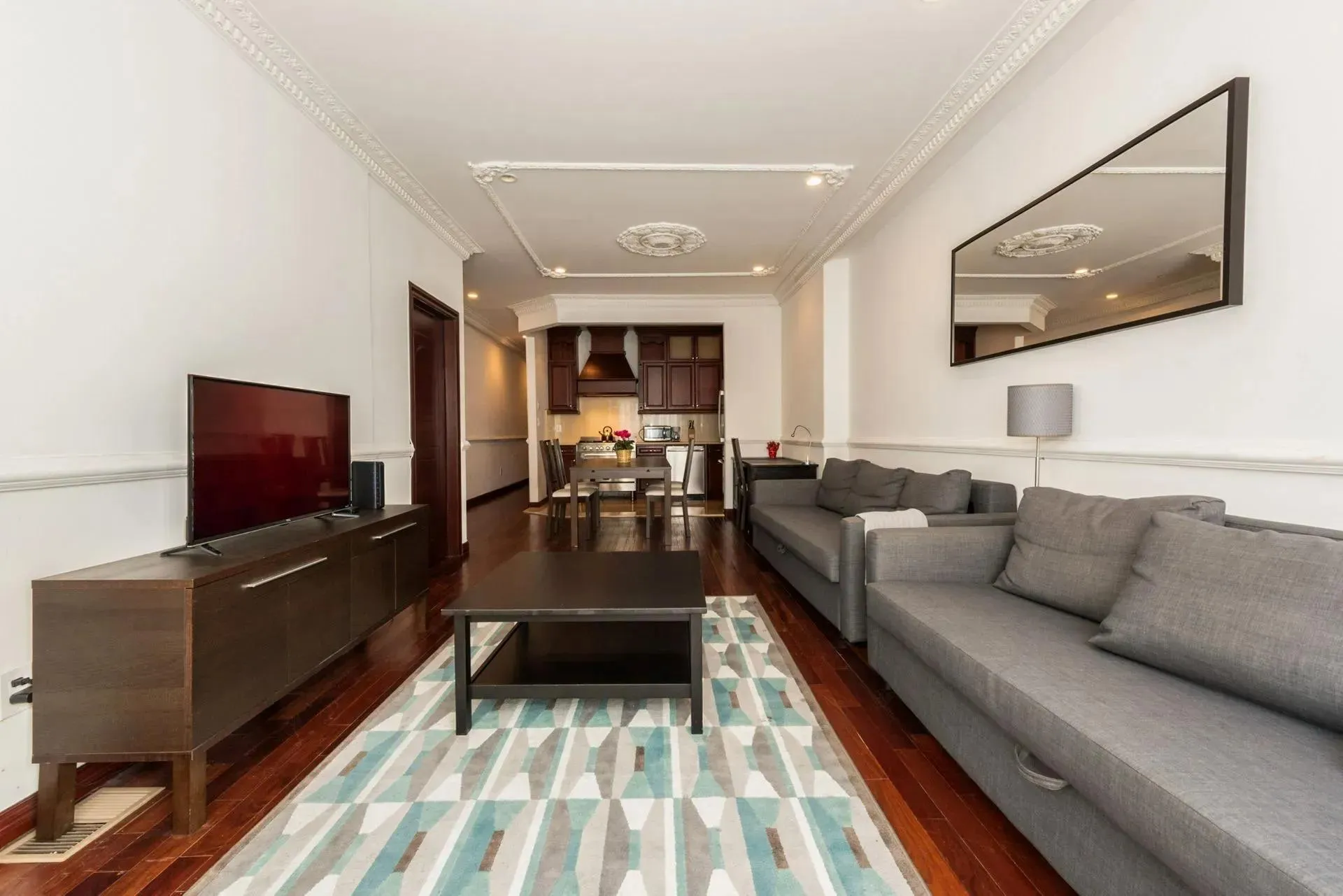 Living room with dark wood-type flooring and crown molding Living room with dark wood-type flooring and crown molding