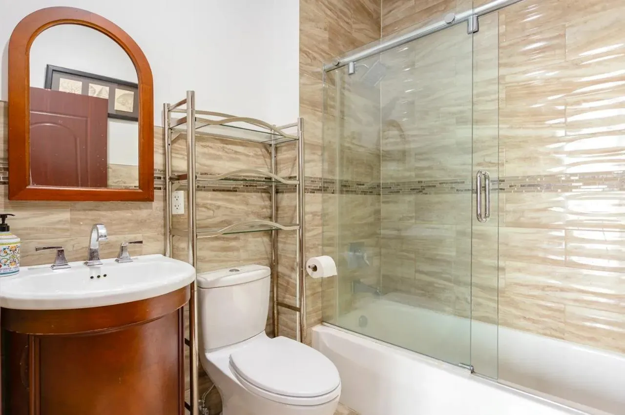 Full bathroom with shower / bath combination with glass door, vanity, tile walls, and backsplash Full bathroom with shower / bath combination with glass door, vanity, tile walls, and backsplash