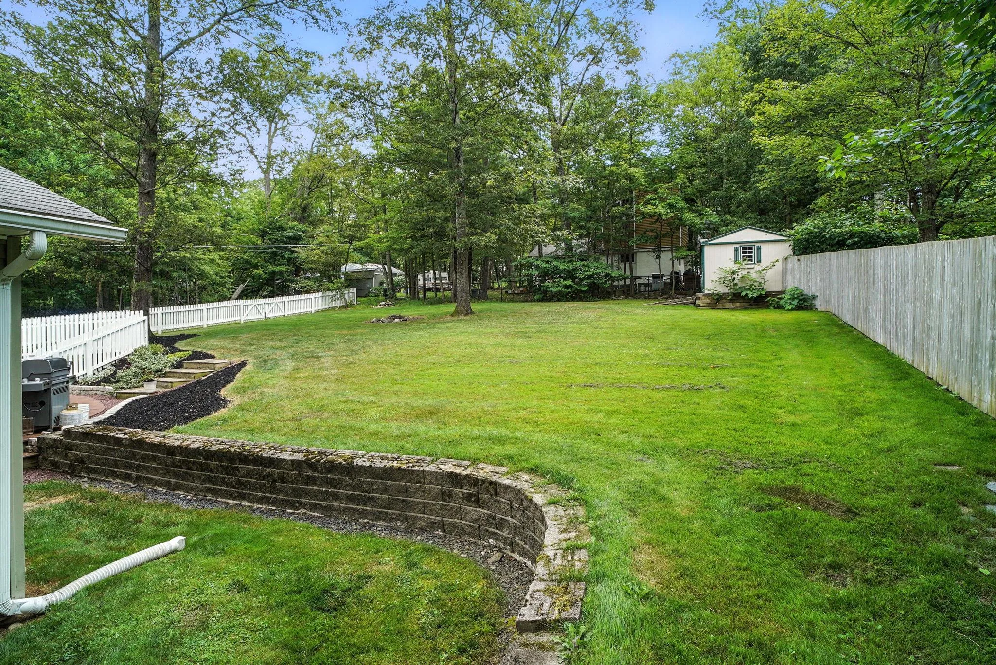 Fenced backyard featuring a storage unit Fenced backyard featuring a storage unit