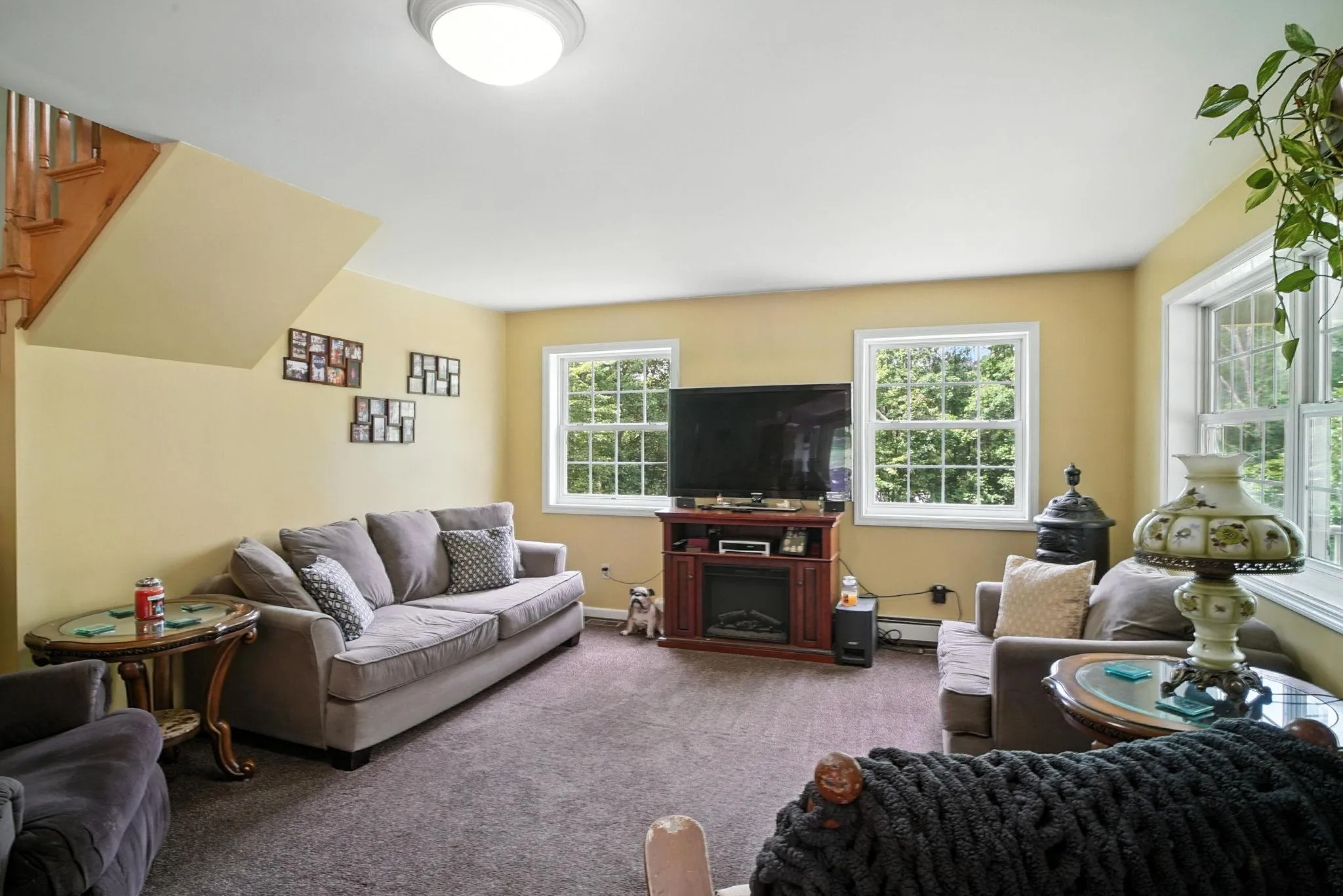 Carpeted living room with a fireplace and baseboards Carpeted living room with a fireplace and baseboards