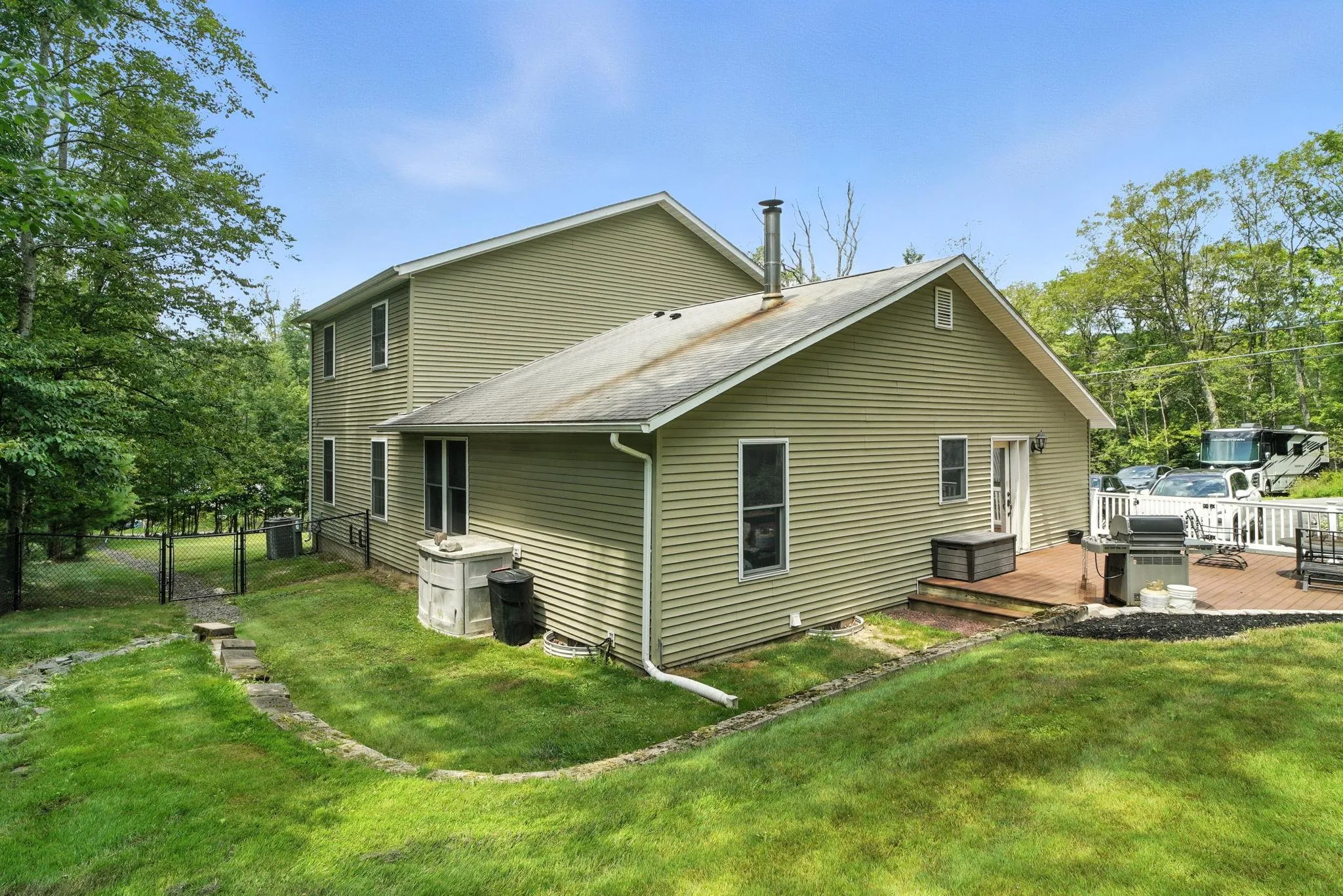 Rear view of house with a deck and roof with shingles Rear view of house with a deck and roof with shingles