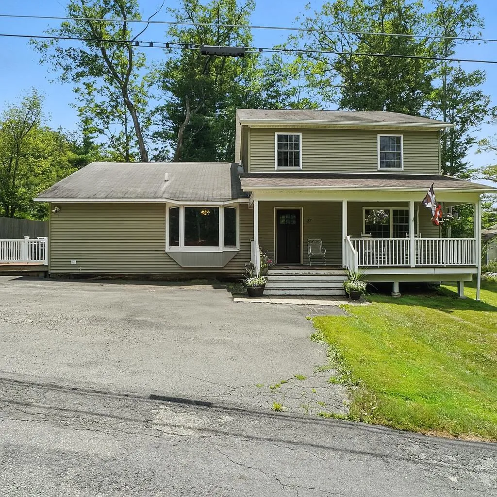 View of front of property with covered porch and a front lawn View of front of property with covered porch and a front lawn