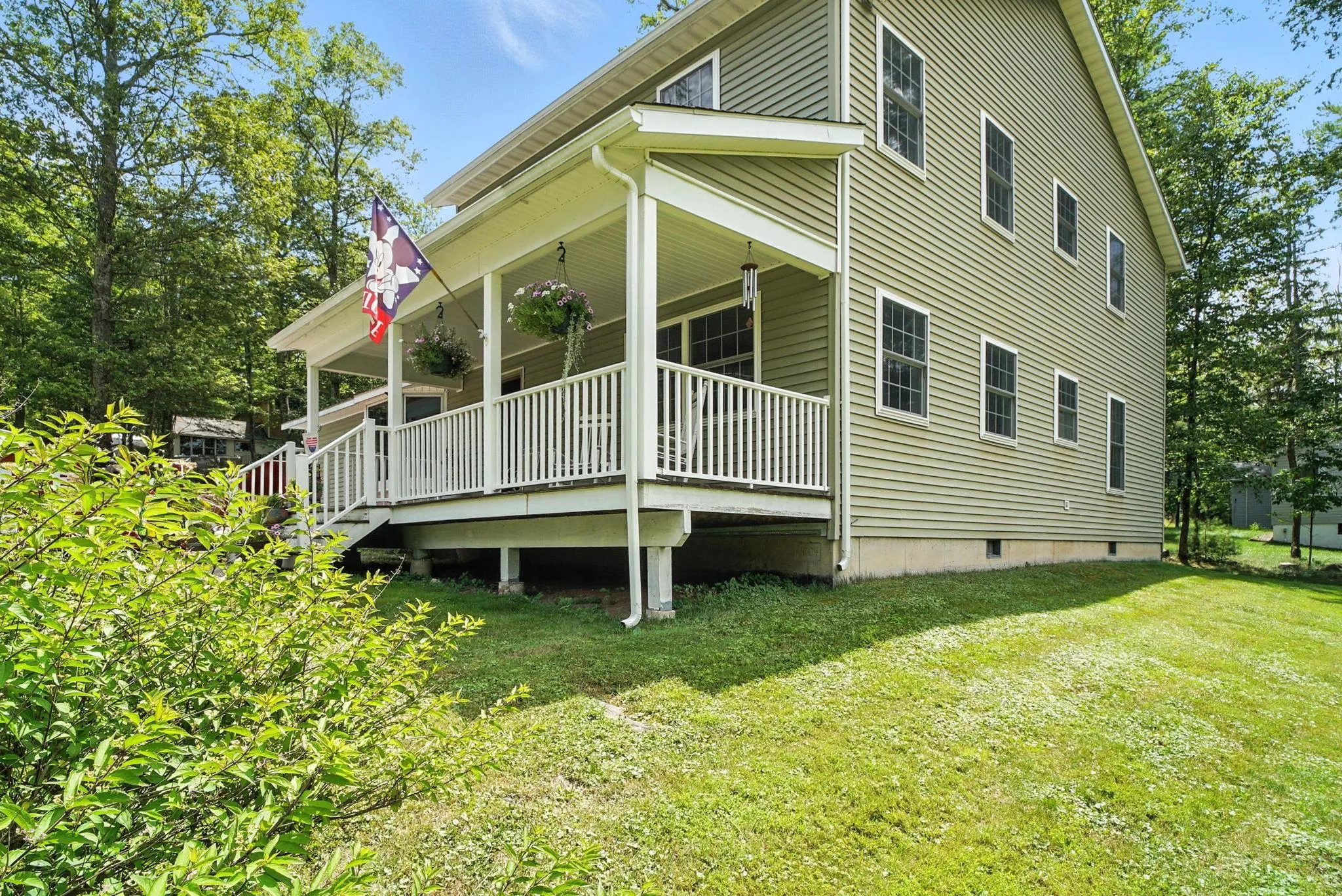 View of side of home with covered porch and a lawn View of side of home with covered porch and a lawn